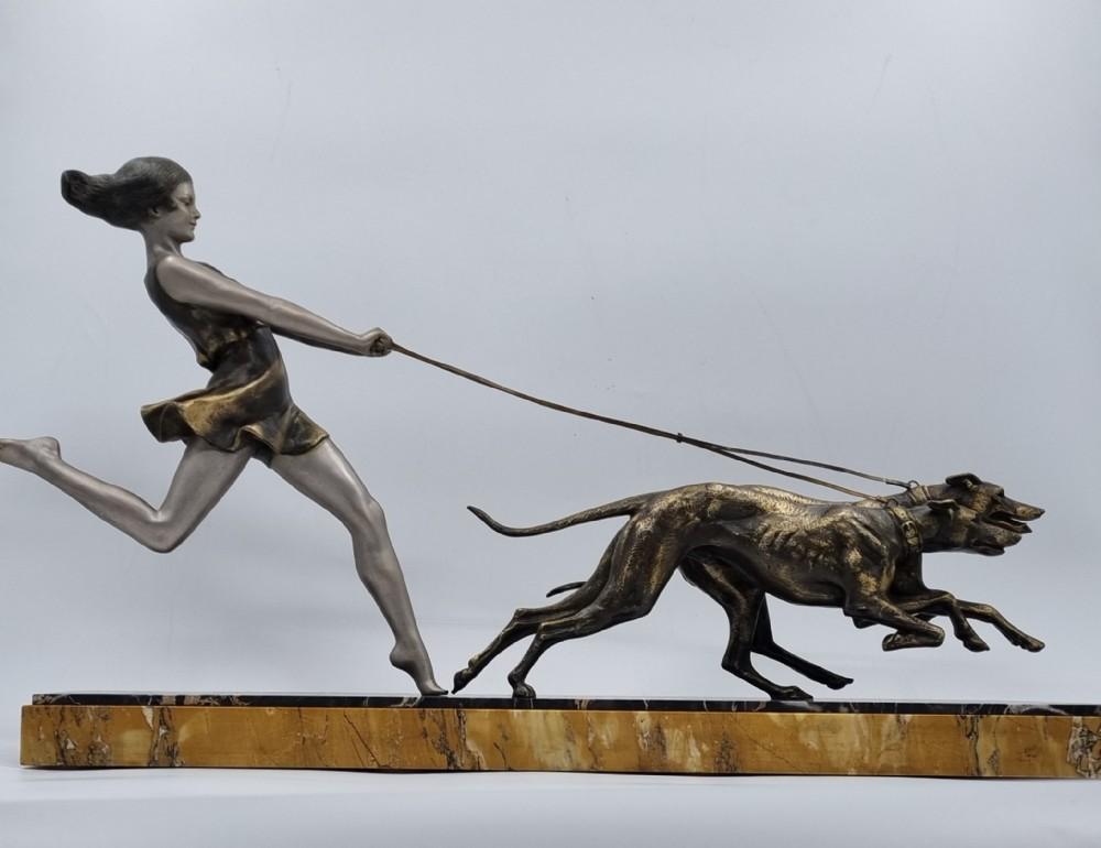 An original Art Deco Sculpture / Girl with flowing dress / hair running with two streamlined greyhounds on Double tone portoro Marble Base. Signed by well known French Art Deco artist Geo Maxim. Sculpture is stamped with the original foundry Mark.