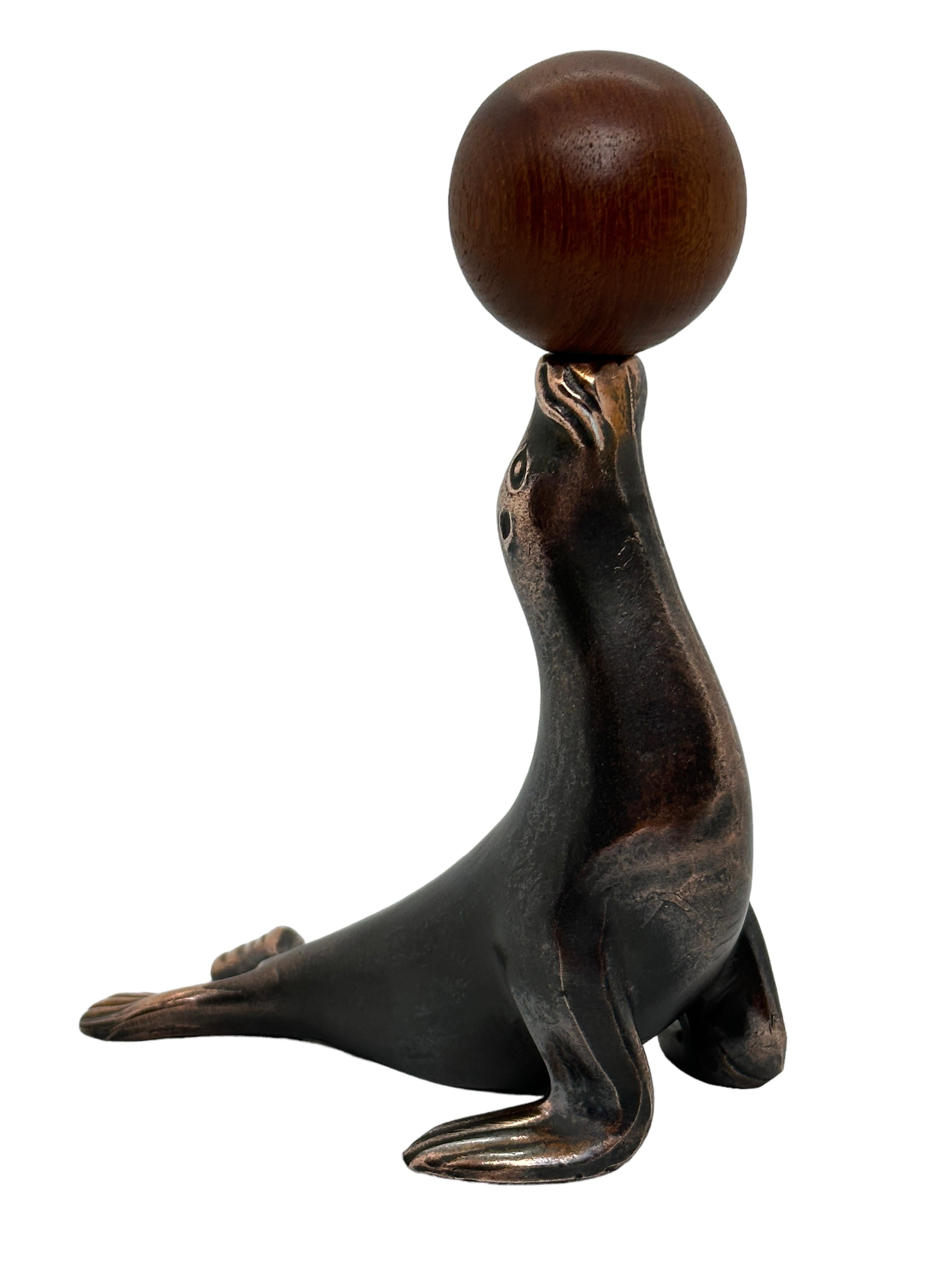 Klassischer österreichischer Korkenzieher der frühen 1960er Jahre oder älter in Form eines Seelöwen oder einer Robbe, die eine Kugel balanciert. Die Kugel ist gleichzeitig der Griff für den Korkenzieher. Eine schöne Ergänzung für Ihr Zimmer oder