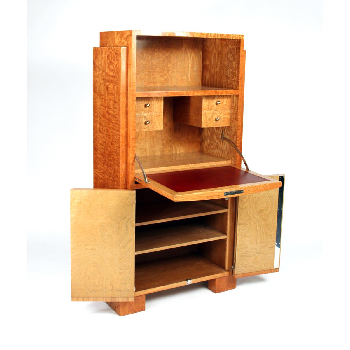 Ce bureau secret a été conçu par Jacques Adnet, et a été réalisé en bois de frêne Tamo.  Le style de ce secrétaire se caractérise par des lignes épurées, des formes géométriques et une combinaison de différents matériaux tels que le bois et le cuir