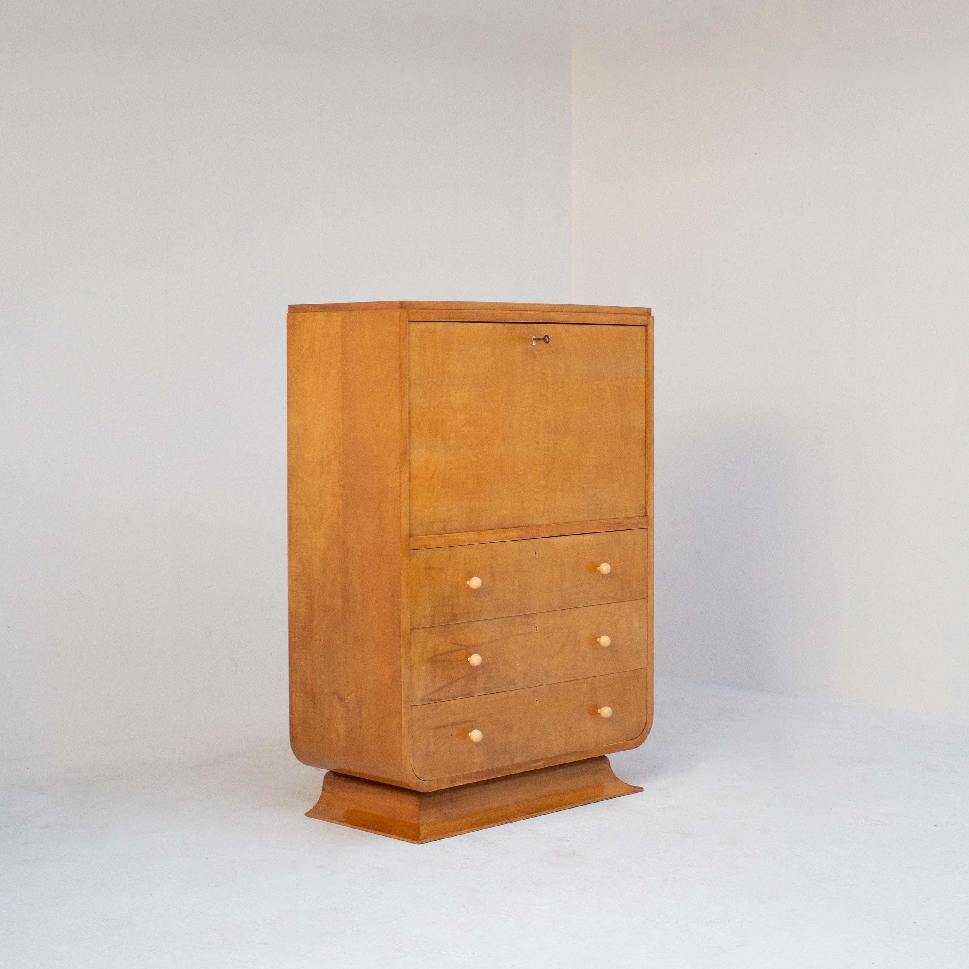 Dieser elegante Art-Déco-Sekretärschrank stammt aus der Mitte des 20. Jahrhunderts und besticht durch den zeitlosen Charme des stromlinienförmigen Designs. Er ist aus warmtonigem Holz mit glatter Maserung gefertigt und verfügt über weiche,