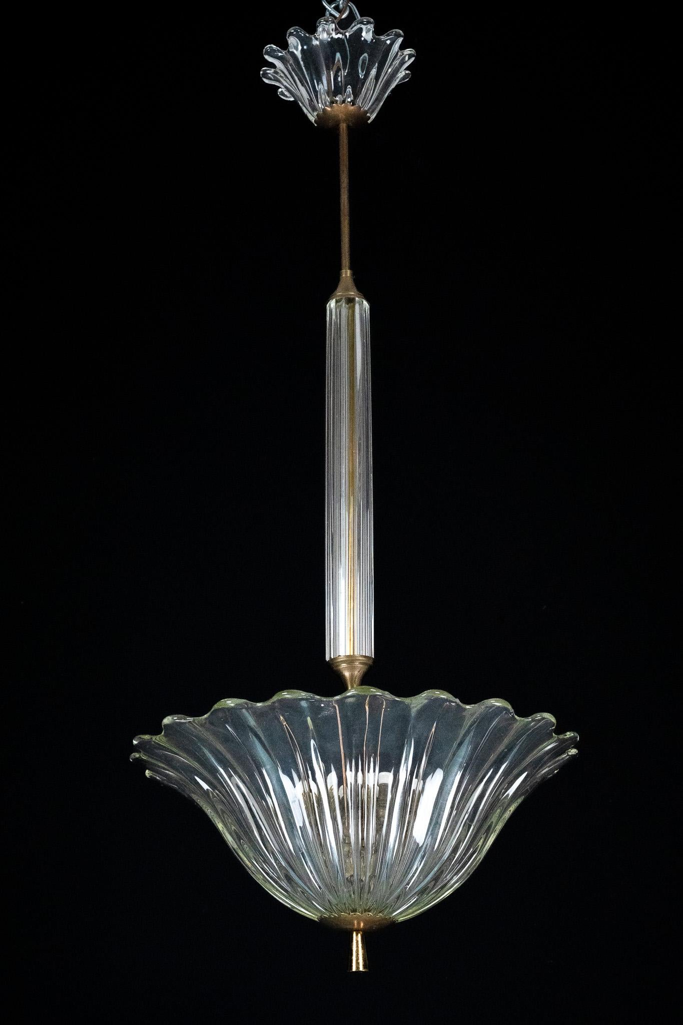 Elegant Art Deco pendant lamp crafted in clear blown Murano glass with refined brass details. The design features a delicately fluted glass bowl reminiscent of an open flower, complemented by a matching upper element that echoes the same organic