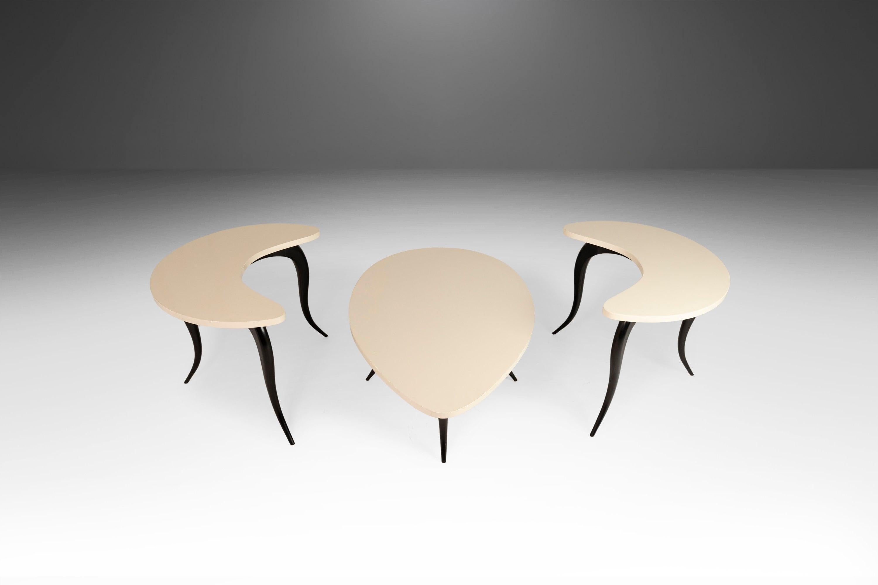 Visually captivating. Audaciously shaped. This gorgeous set of tables, styled after Osvaldo Borsani, is the epitome of 'functional art'. All audaciously shaped with the tear-drop top of the coffee table and the crescent moon tops of the two matching