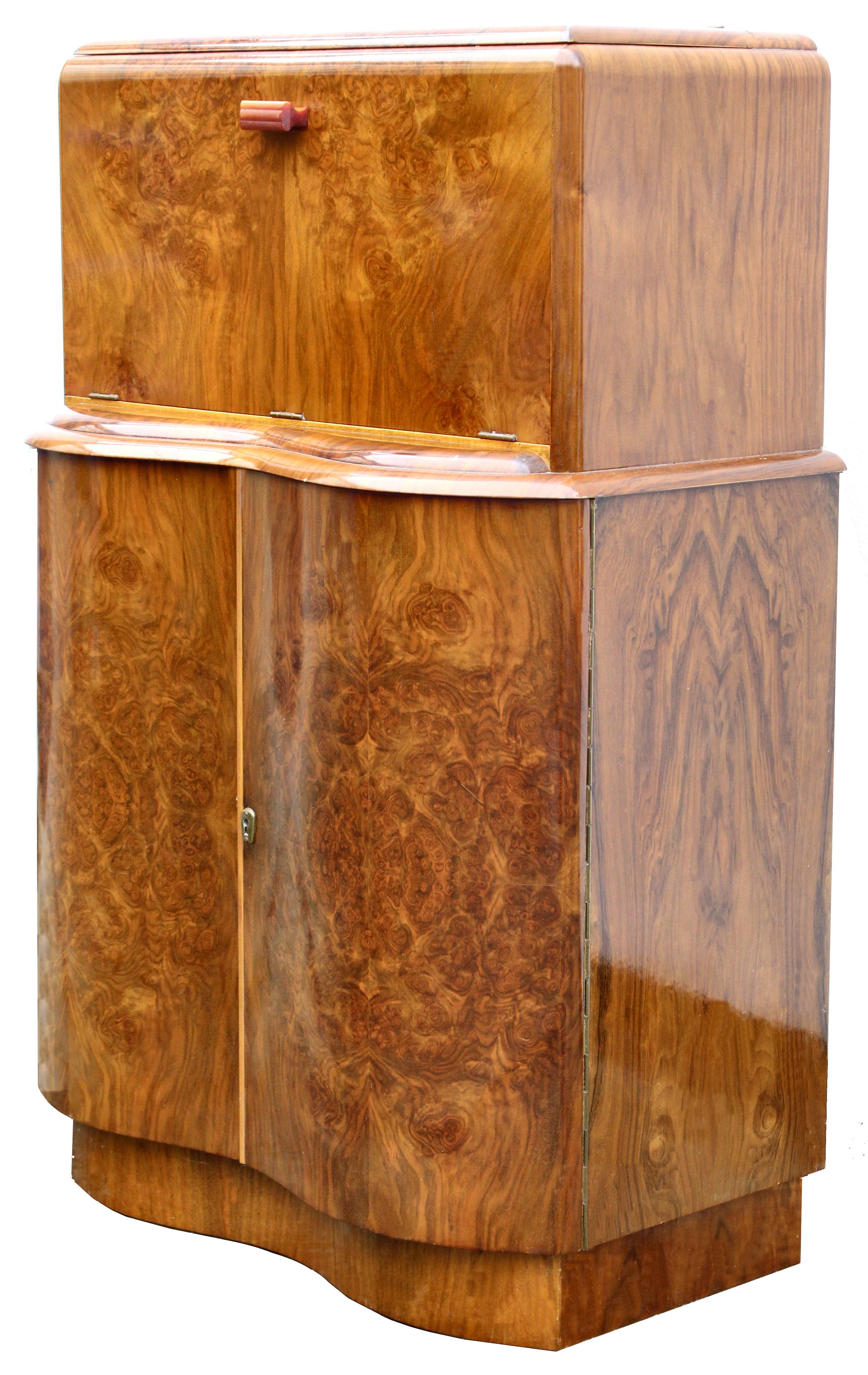 Beautiful 1930s Art Deco walnut serpentine shaped cocktail cabinet in gorgeous figured veneers, every Deco interior should have one of these! Features a drop down top which reveals an all mirrored interior which acts as storage for glasses. Still