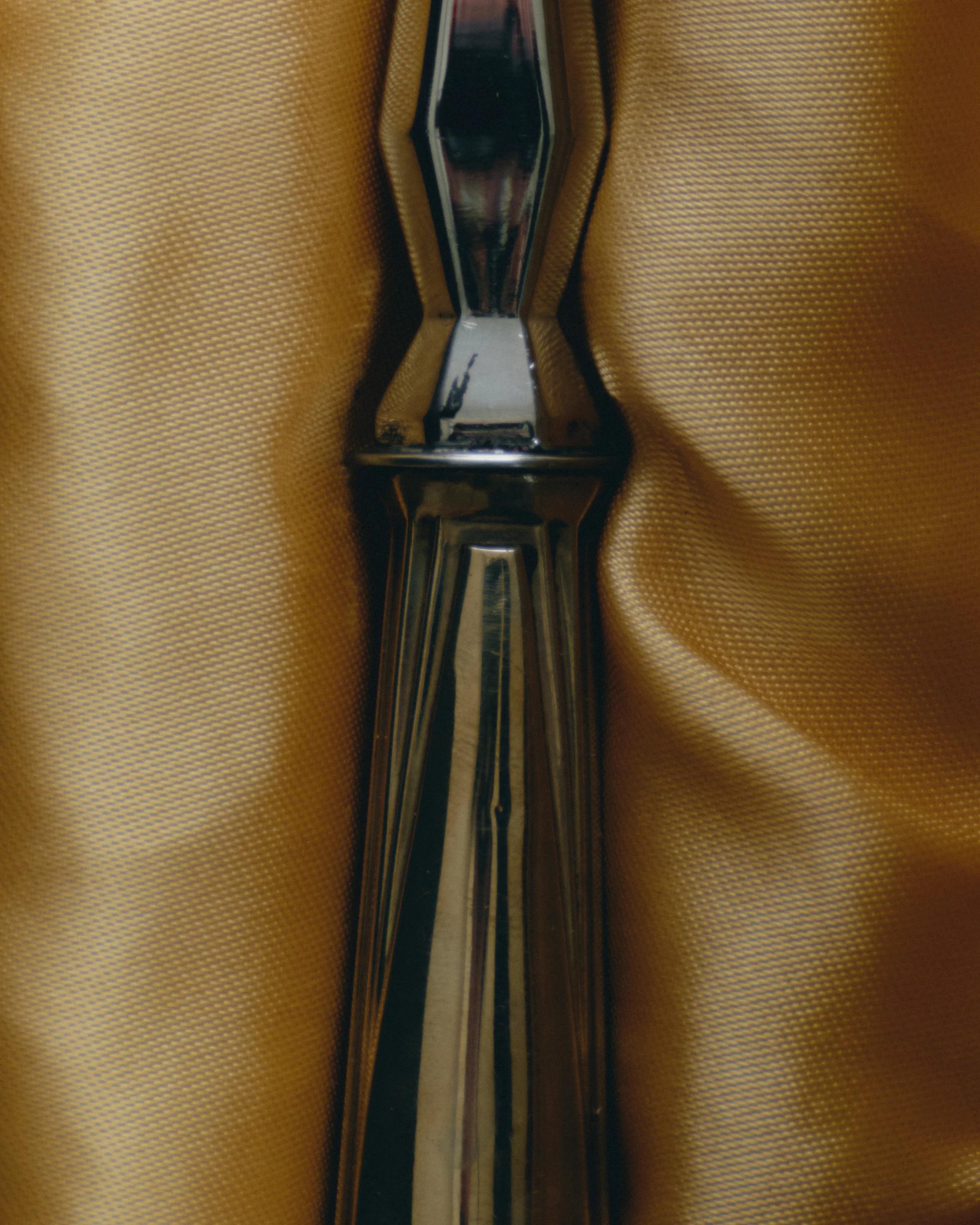 Versilberter Servierlöffel mit geometrischem Dekor, typisch für die Zeit des Art déco. Facettierter, mit symmetrischen Reliefs verzierter Griff, fein ziselierte Dreikantklinge. Präsentiert in der mit Leder bezogenen Originalschachtel. Europäische