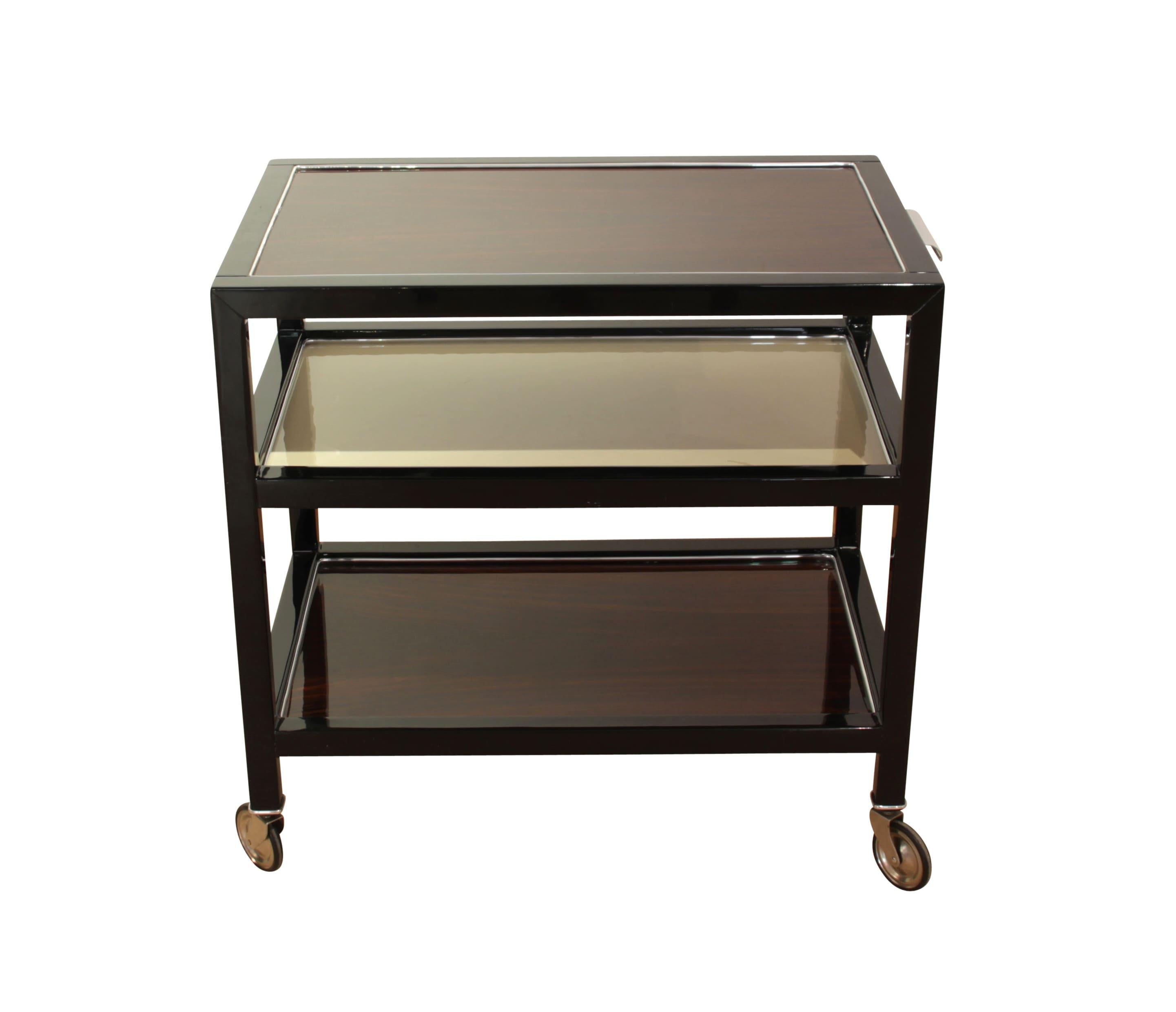 Beautiful Art Deco Serving Table, Rosewood and Black Lacquer, France, circa 1940

Rosewood veneer (upper and lower plate). Frame in black piano lacquer, middle bottom in cream-white lacquer.
Silver-colored ribbon around the top plate. Mobile on 4