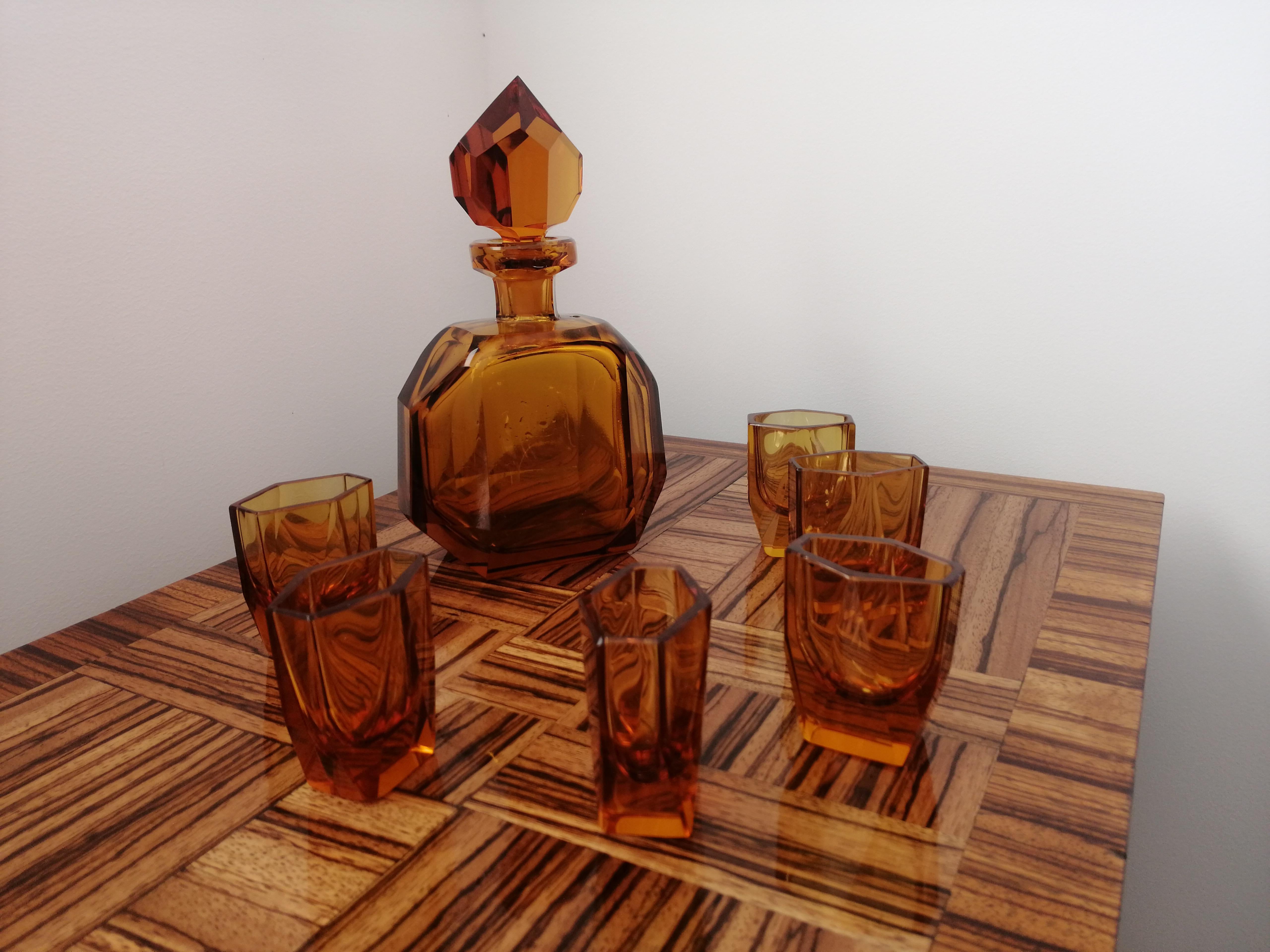 Ich biete Ihnen ein klassisches Art-Déco-Set aus einer Karaffe und 6 Gläsern an, das in den 1930er Jahren in Karlsbad (dem heutigen Karlove Vary in der Tschechischen Republik) in der renommierten Kristallglasfabrik Ludwik Moser hergestellt wurde,