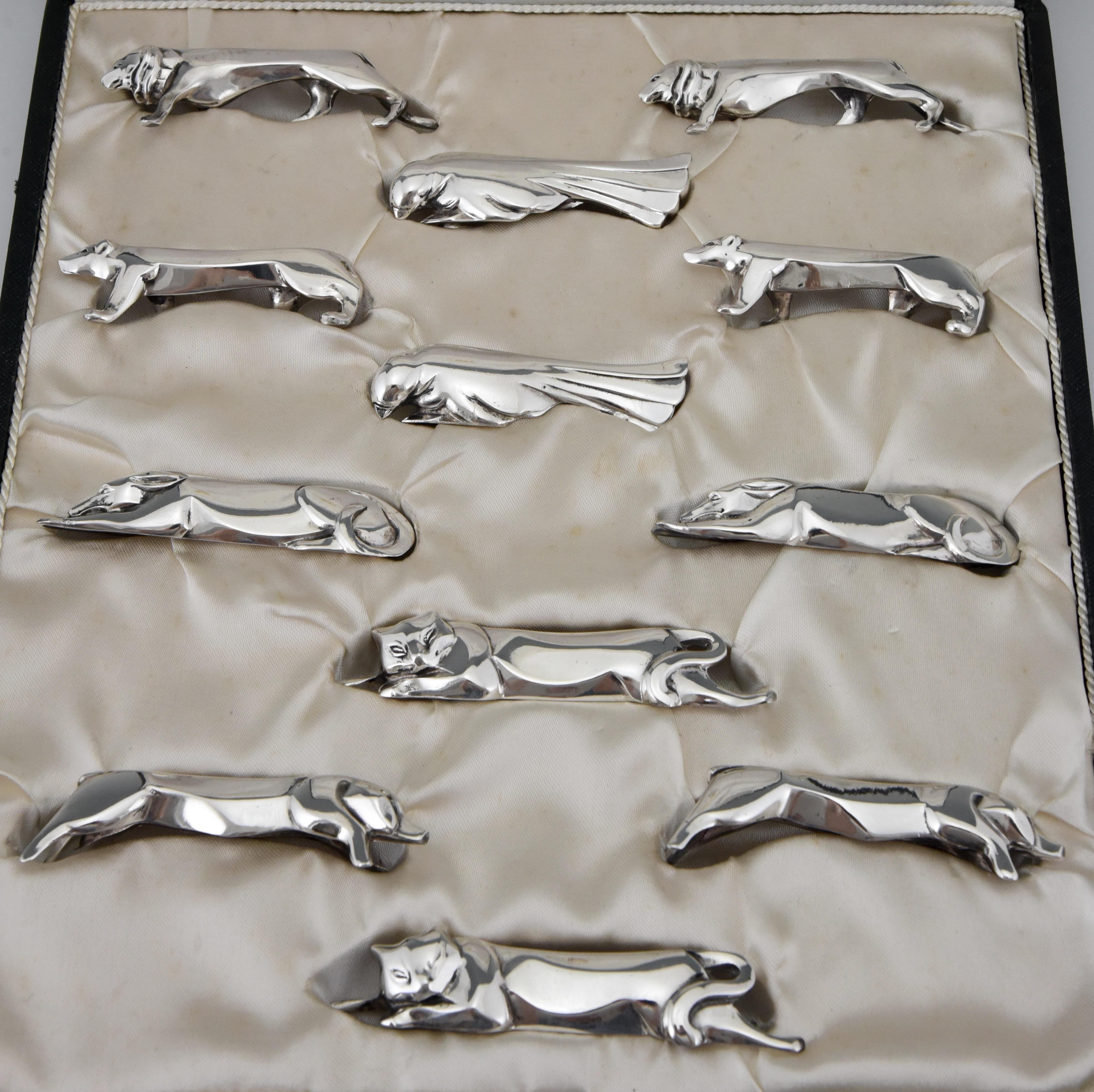 A set of 12 Art Deco silver plated animal knife rests by Sandoz for Gallia in original case, France, 1930. 
2 x lion, dove, polar bear, dog, cat end pig.
Size of the case:
H. 4 cm x L. 32 x. W. 28 cm.
H. 1.6 inch x L. 12.6 inch X W. 11