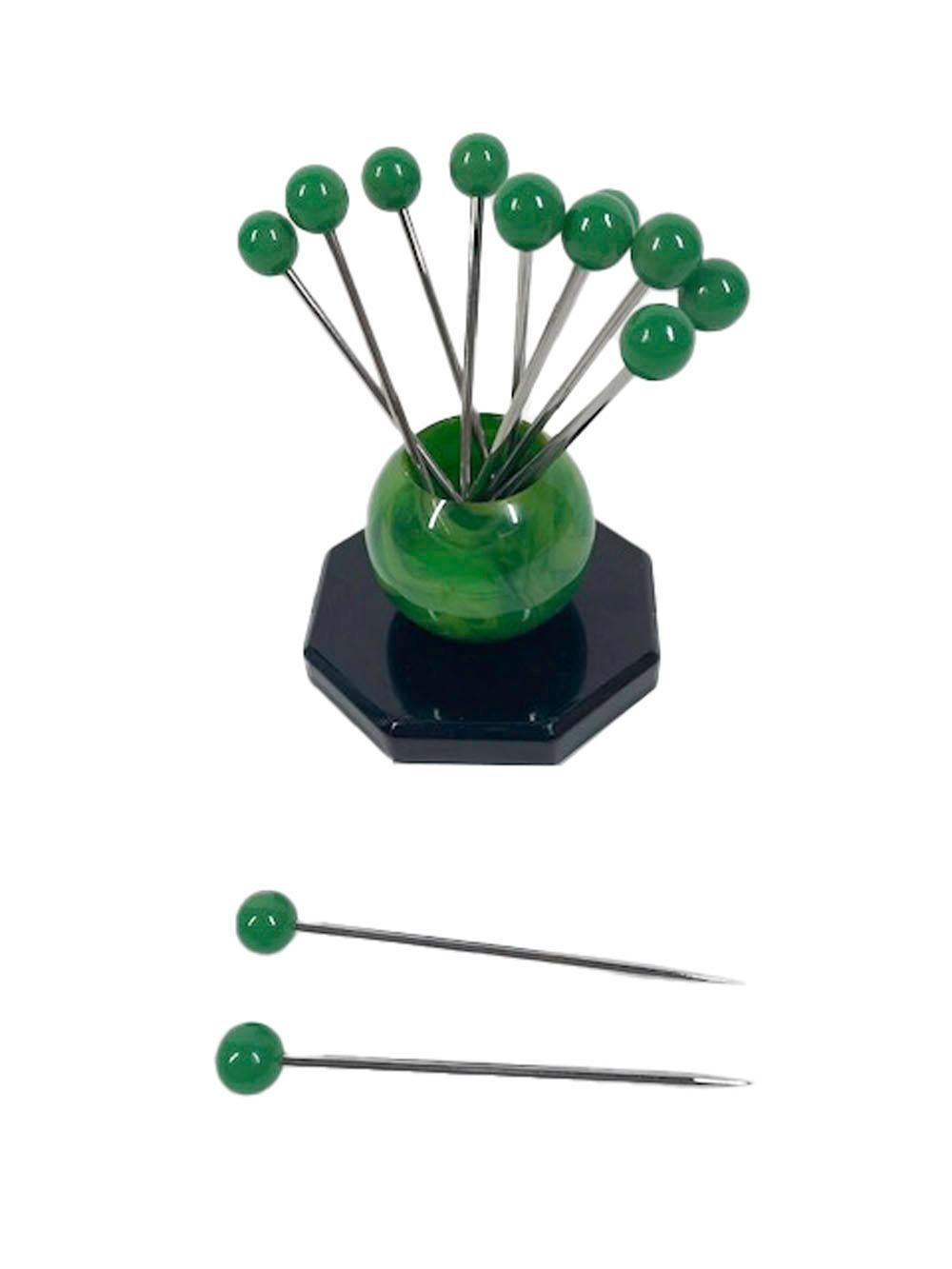 French Art Deco cocktail picks and stand, 12 stainless steel picks with green ball tops in a mottled jade green Bakelite orb standing on an octagonal black Bakelite base.