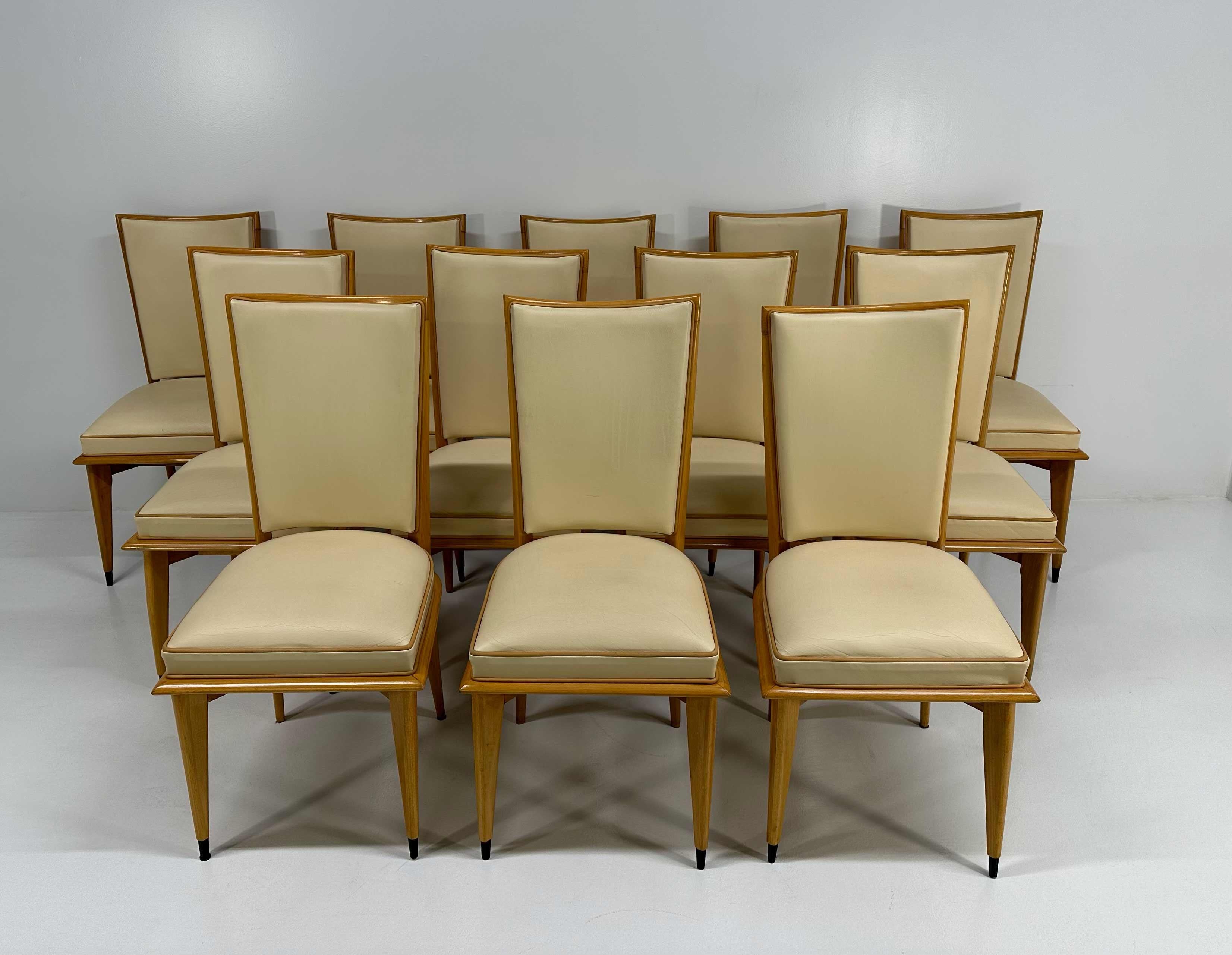 Questo set di 12 sedie Art Déco è stato prodotto negli anni Trenta. Hanno una struttura in acero e sono rivestite con due diversi colori di pelle: crema e marrone chiaro per i profili. 
Le punte delle gambe sono laccate di nero.

Misure: 47cm x 49cm
