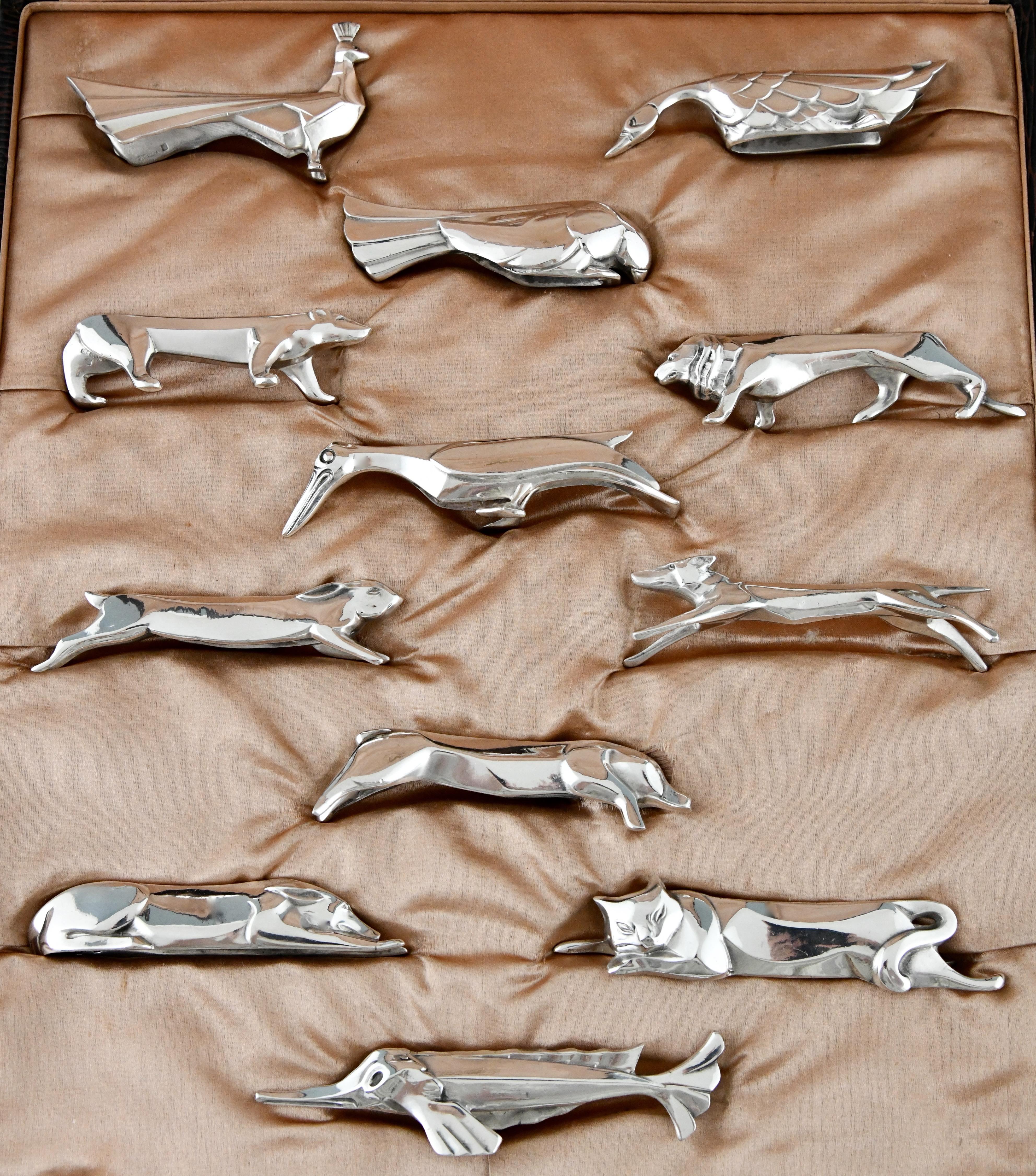 A set of 12 art deco silver plated animal knife rests by Sandoz for Gallia in original case, France, 1930. 
 
Size of the case:
H. 4 cm x L. 32 x. W. 28 cm.
H. 1.6 inch x L. 12.6 inch X W. 11 inch.
Average size of knife rests:
H. 2.5 cm. x L.