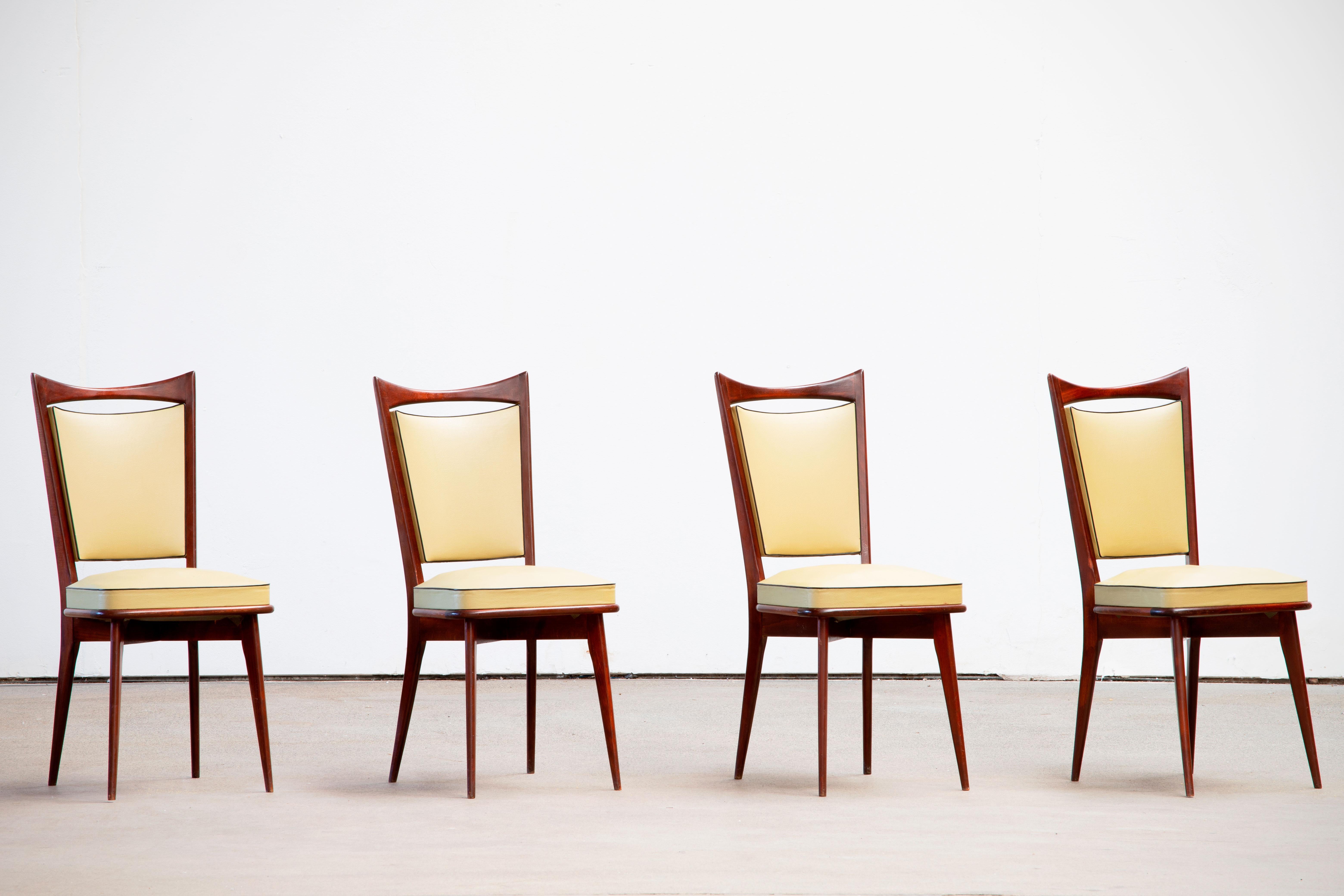 Set of four upholstered high back chairs covered in yellow vynil, in solid mahogany. Polished.
The seat can be restored on request.