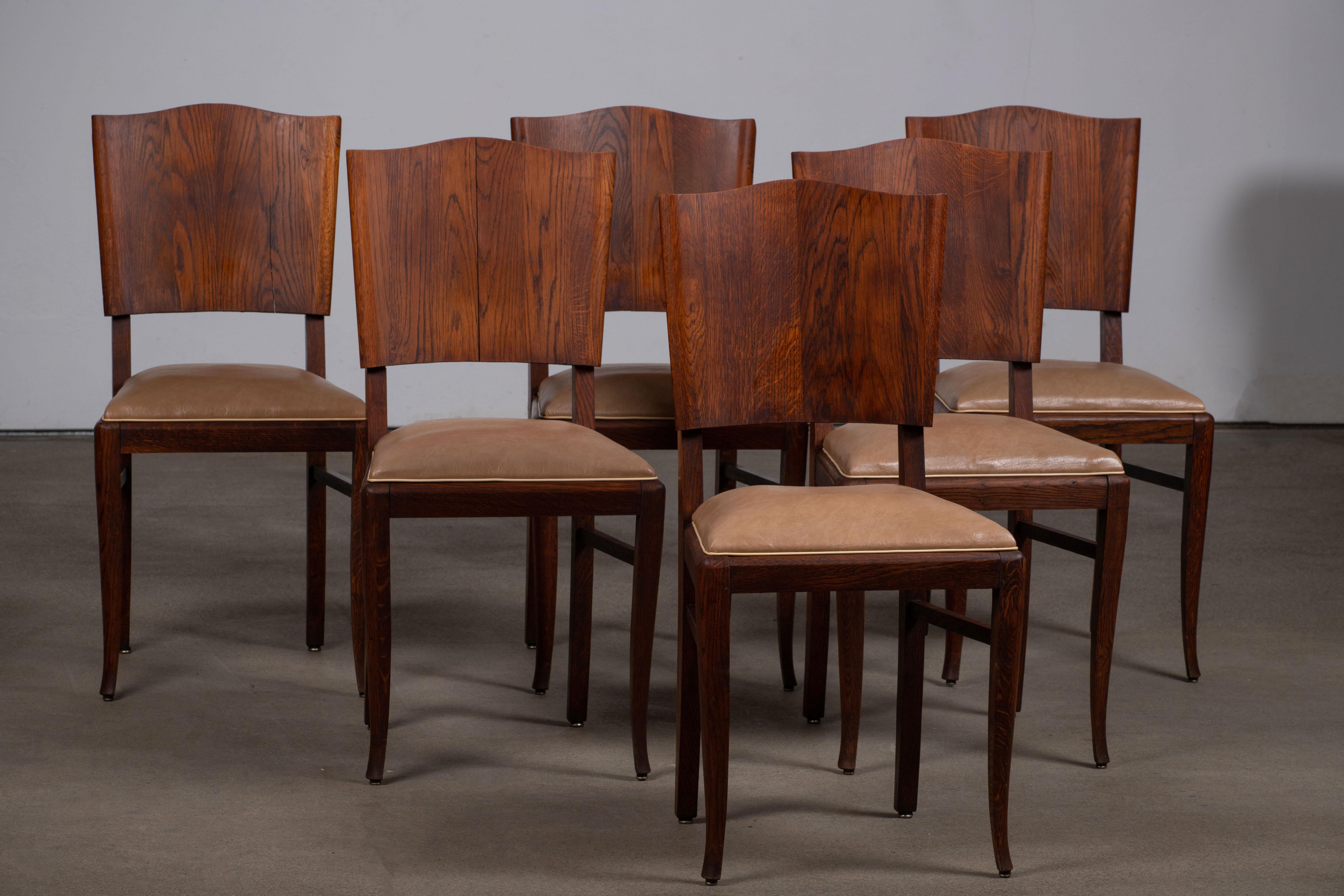 This set of six French Art Deco dining chairs in solid oak was created in the 1940s inspired by the work of Charles Dudouyt.

We can clearly see the work of the French school of the 1940s. The detailed and graphic designed backrest panels will meet