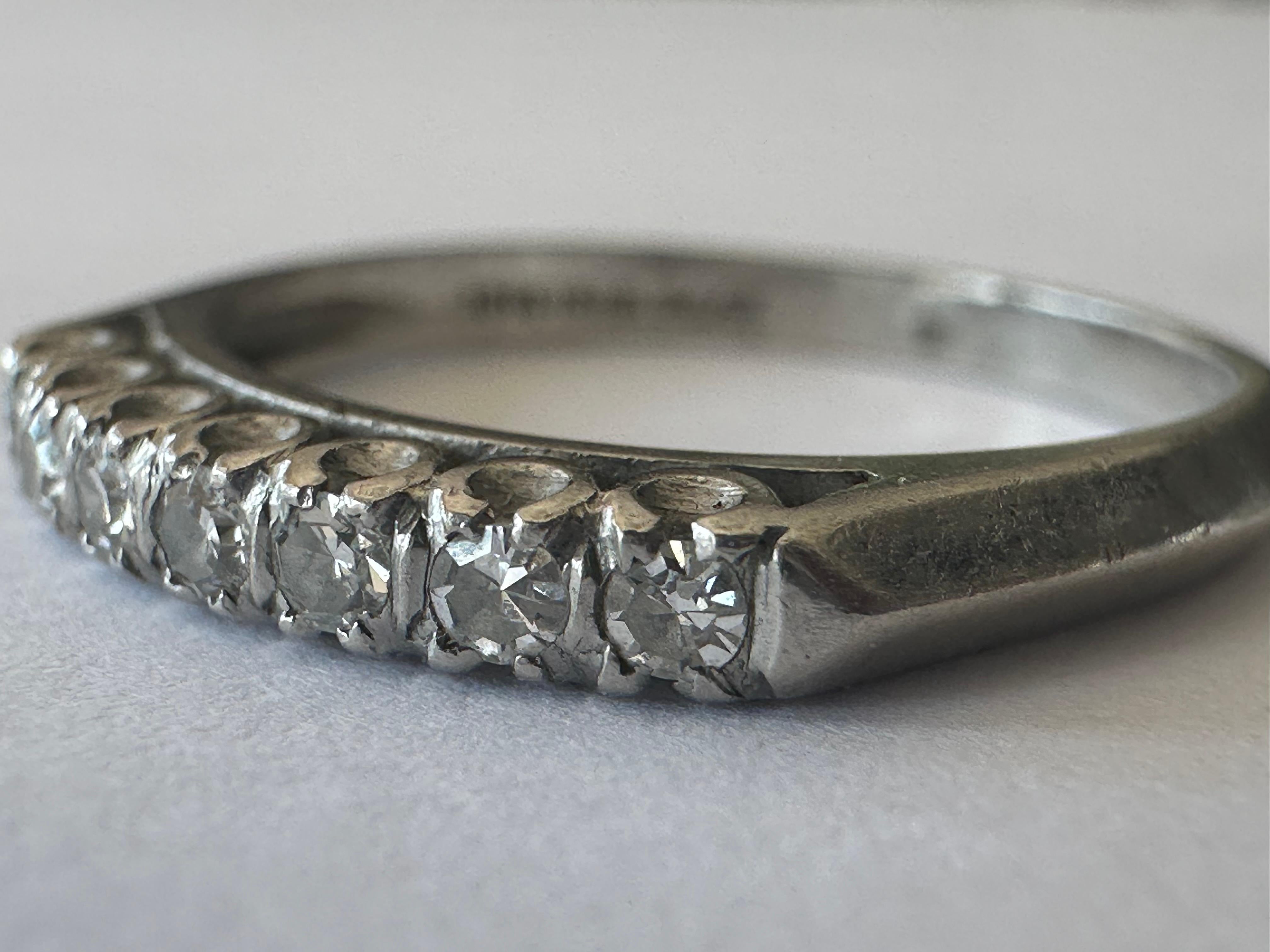 Seven single-cut diamonds totaling approximately 0.14 carat, F color VS clarity, shimmer across the top of this classic Art Deco band handcrafted in platinum. The width of the top of the band measures 2.4mm.