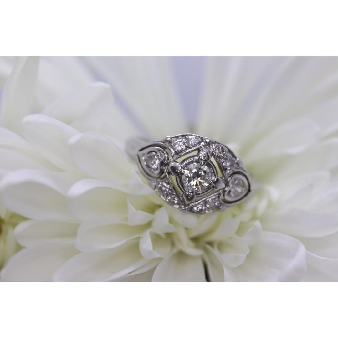 Vintage from the 1930s
Size: 9 1/2 US
Materials: Stone
Gemstone: Diamond
Gem color: Green
Band Color: Silver

Style: Art Deco

Magnificent Diamond shield ring. Filigree 14k White gold.

4mm center Diamond est 0.25ct
2 2.5mm side diamonds est