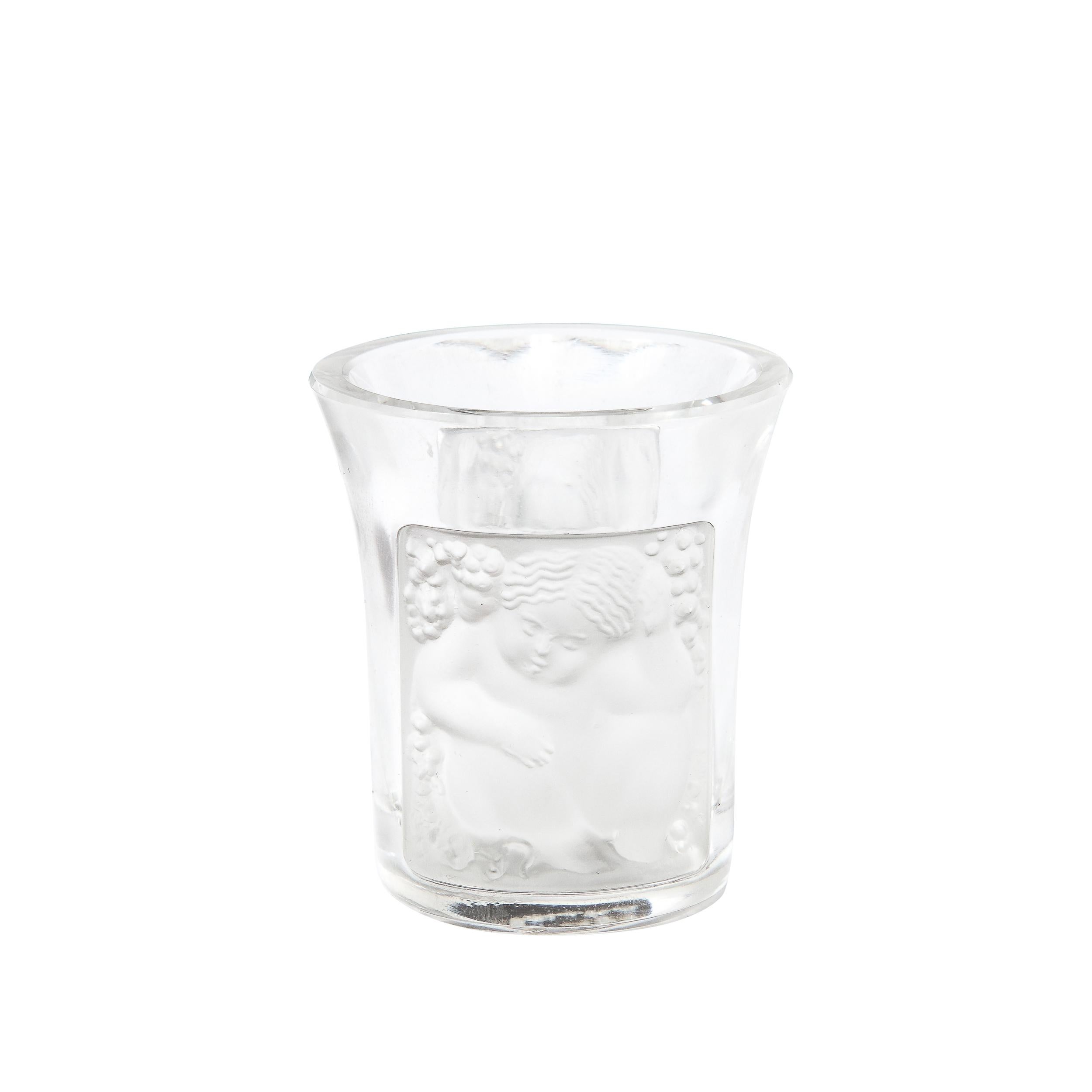 This Art Deco Shot Glass originates from France, Circa 1925. A charming piece rendered in frosted and translucent glass with a subtle inward curve sports two opposite facing motifs of neoclassical figures adorned with grapes in rounded stage like