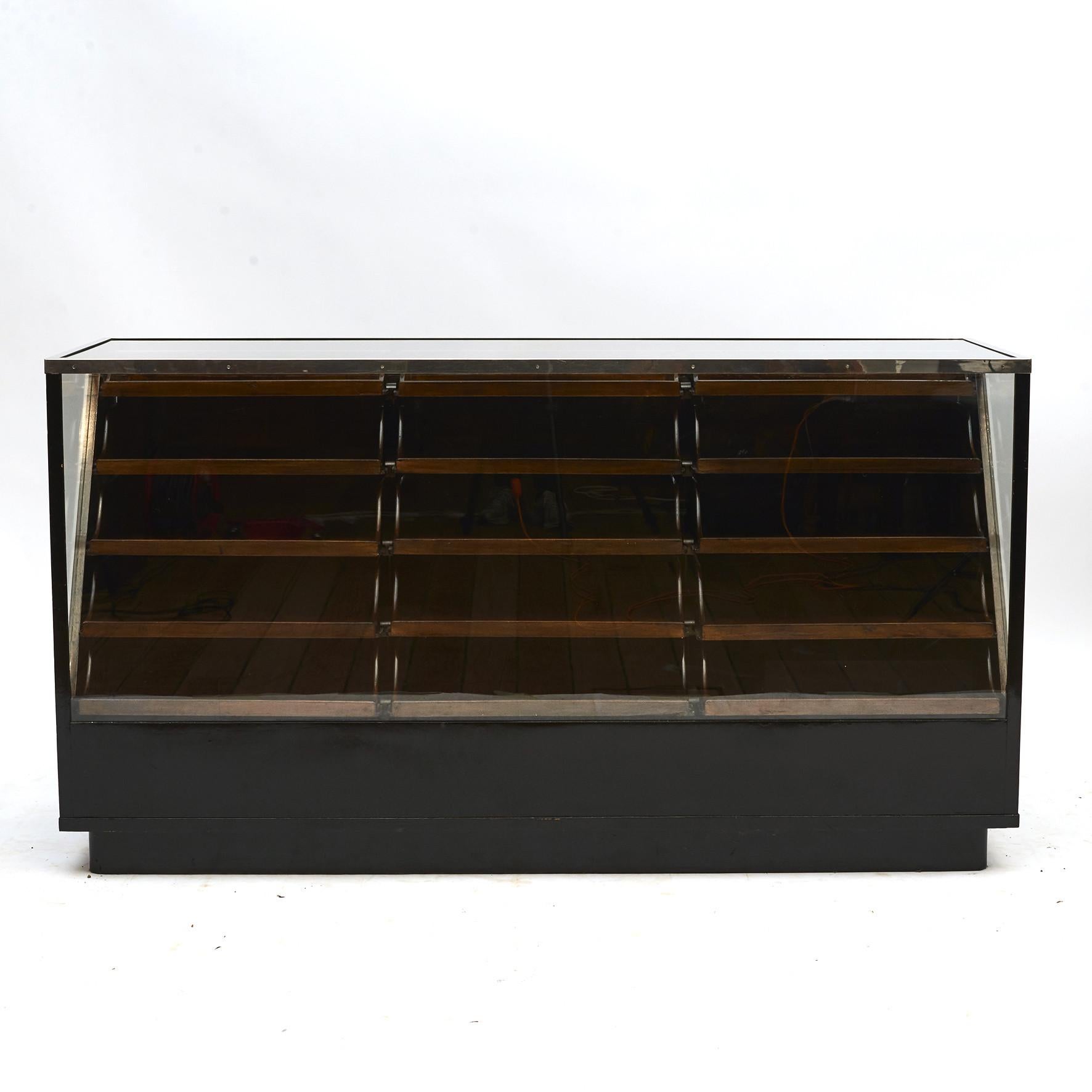 Art Deco store showcase counter in black polished wood and glass.
Glass top with chromed brass trim.
3x6 (18) drawers with original handles with name card holders.

Made by Swedish manufacturer Nässjö AB. Sweden circa 1930.

This is a quality