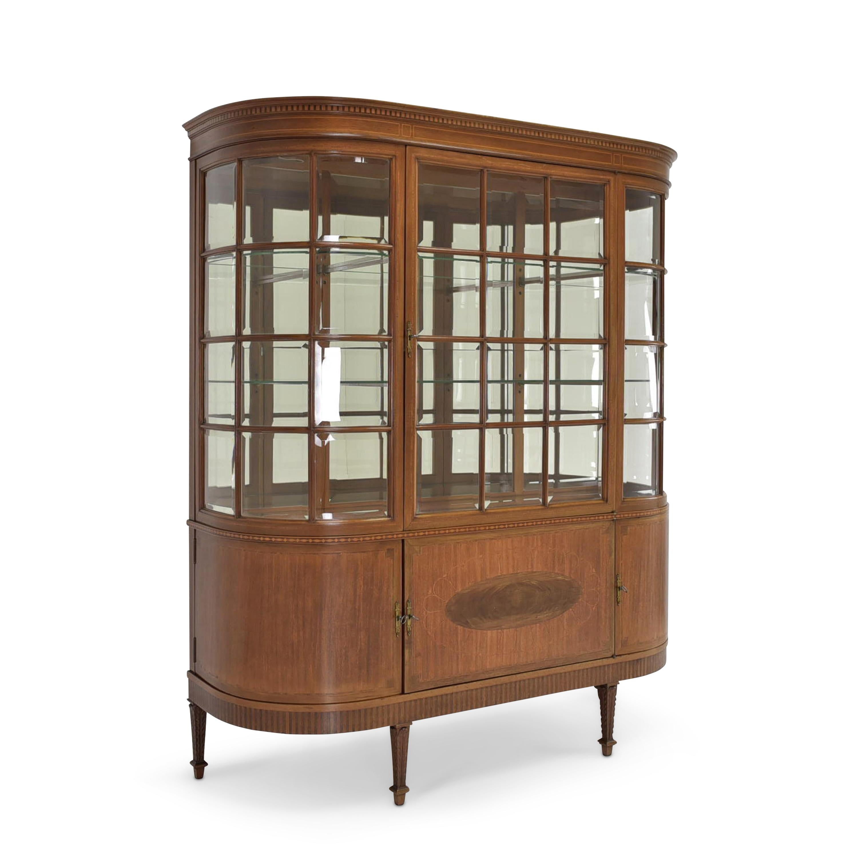 Showcase restored Art Deco around 1925 mahogany showcase

Features:
Interior solid oak, doors inside bird's eye maple
Three-sided glazed model with one door at the top and three in the base unit
Very high quality processing
Original glazing
