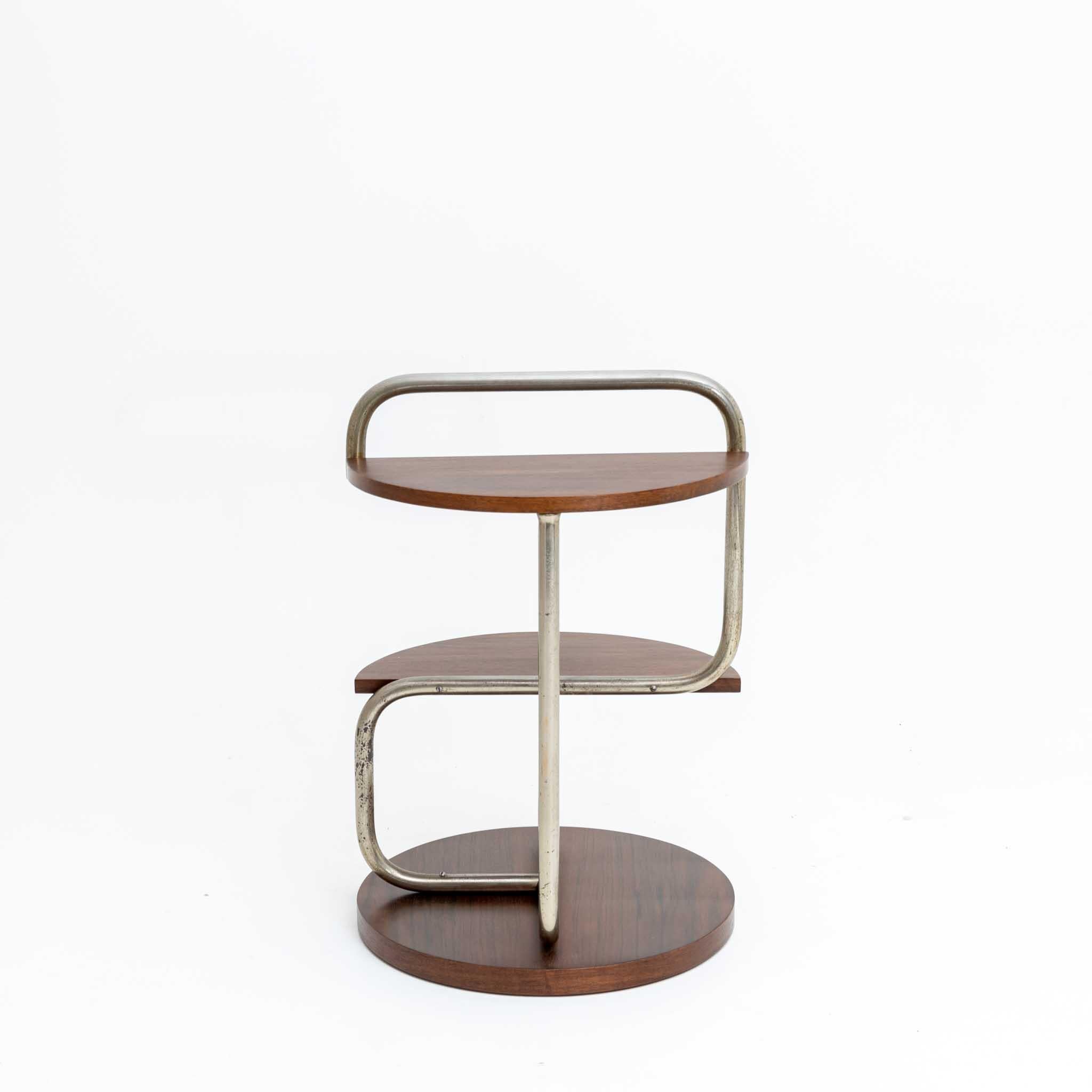 Side table on round stand with curved tubular steel frame with two shelves.
