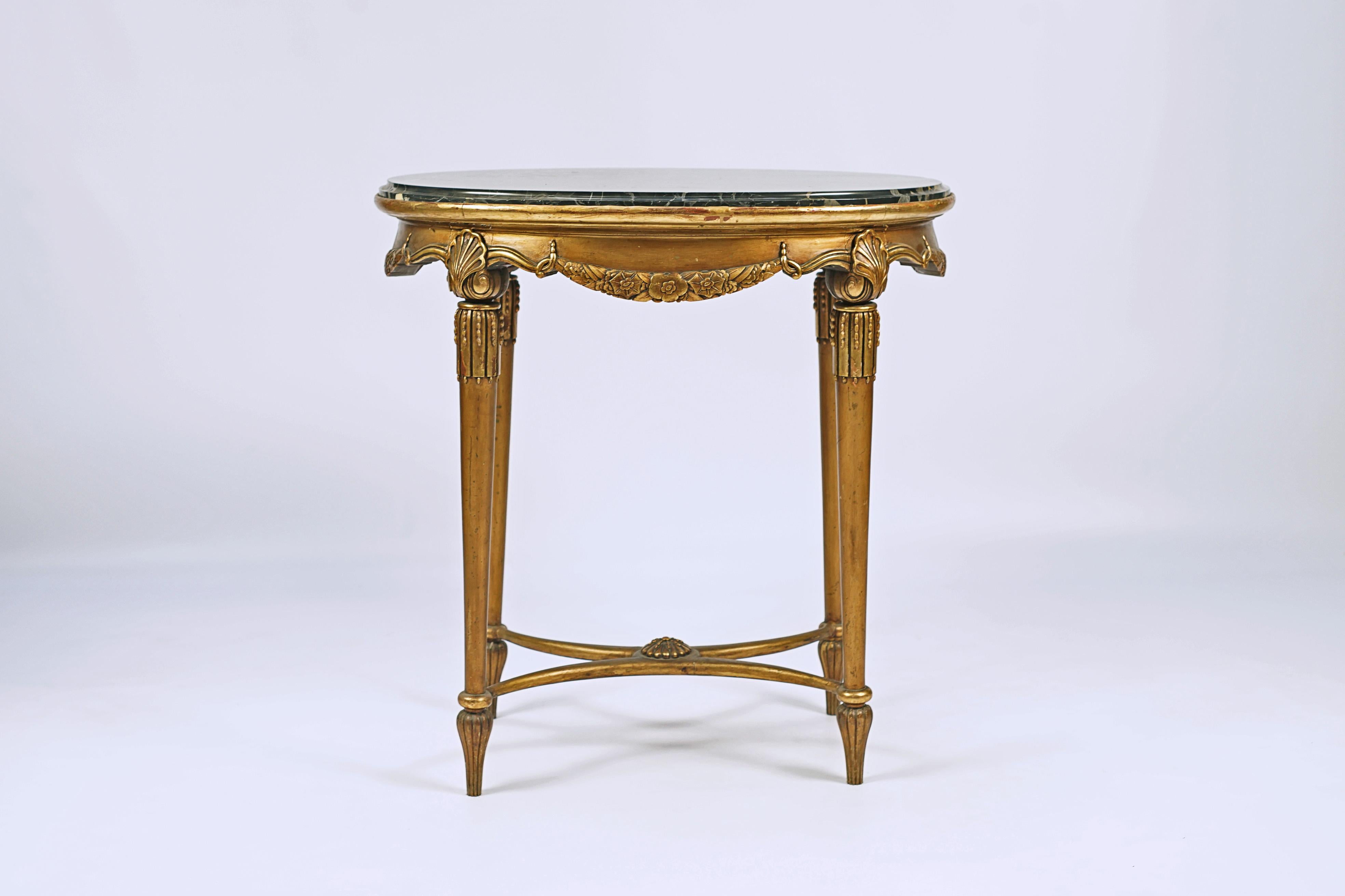 Table d'appoint Art déco conçue par Paul Iribe (1883-1935). Bois sculpté avec finition à la feuille d'or et marbre travertin.

France, CIRCA 1920.