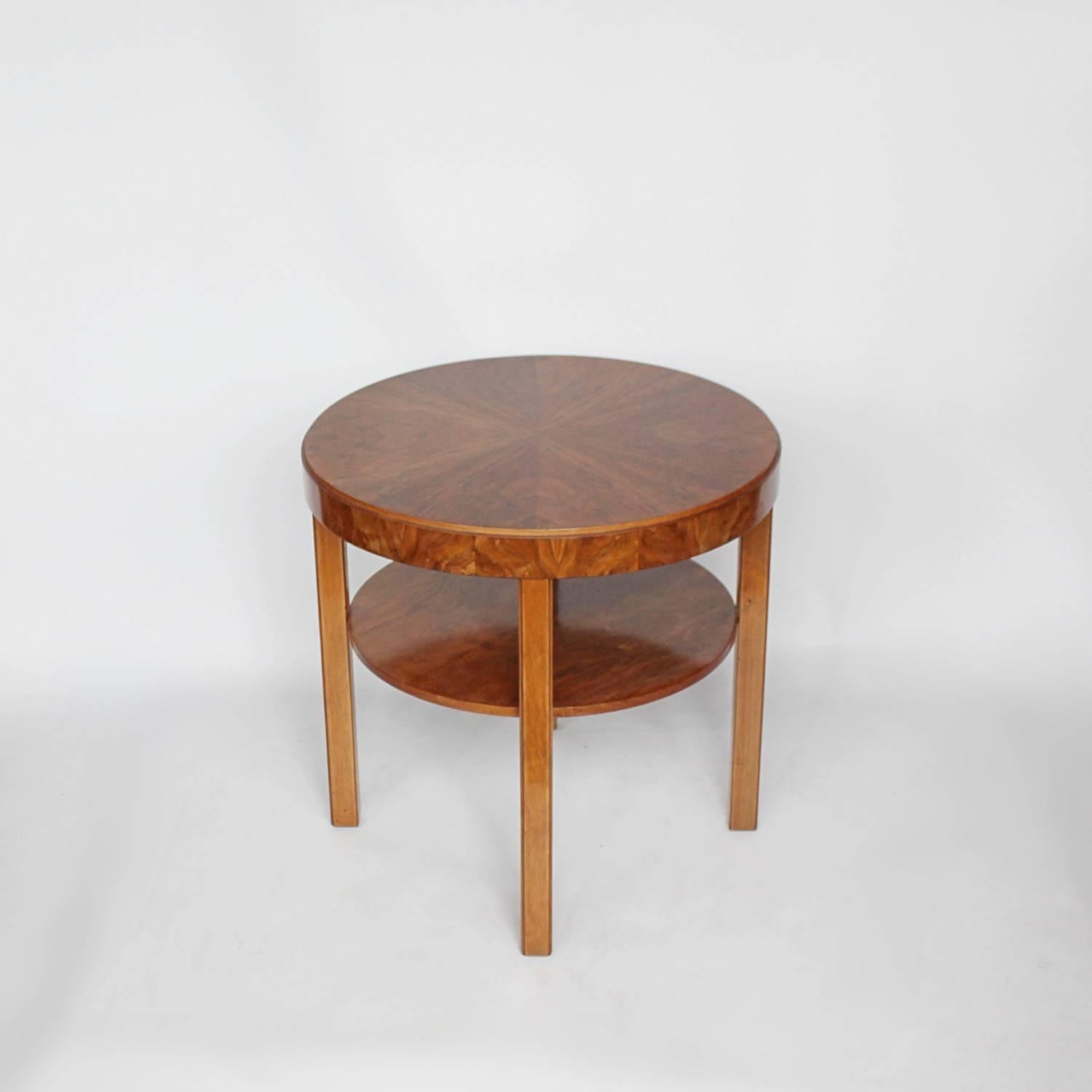 An Art Deco, circular side table with integral shelf in figured walnut.

 