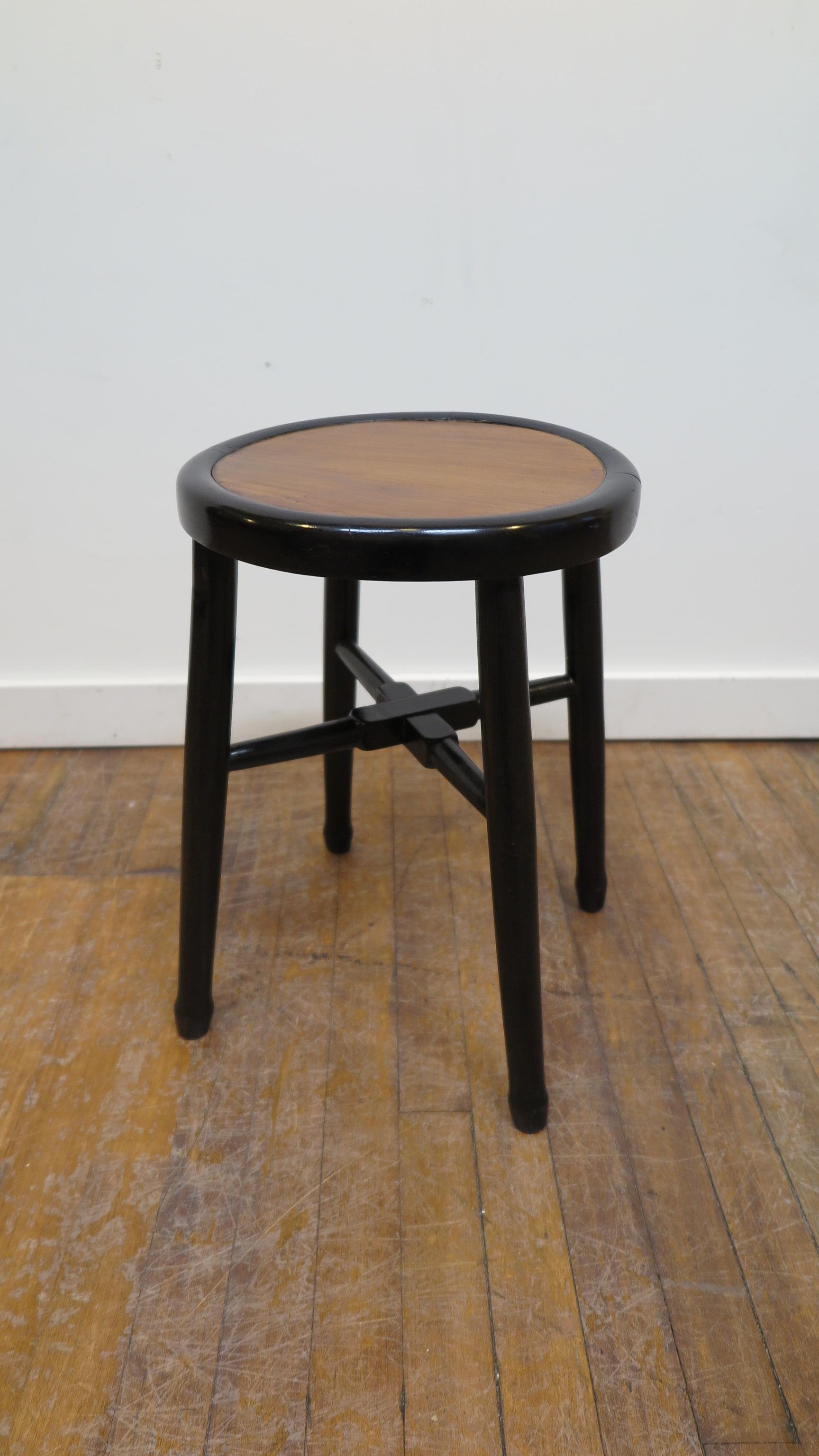 Art Deco round stool side table of elm wood. Black lacquer body with elm top showcasing a brilliant contrast of natural color with the black Lacquer. In very good condition. Last two pictures are of the joining seam of the joinery detail for the