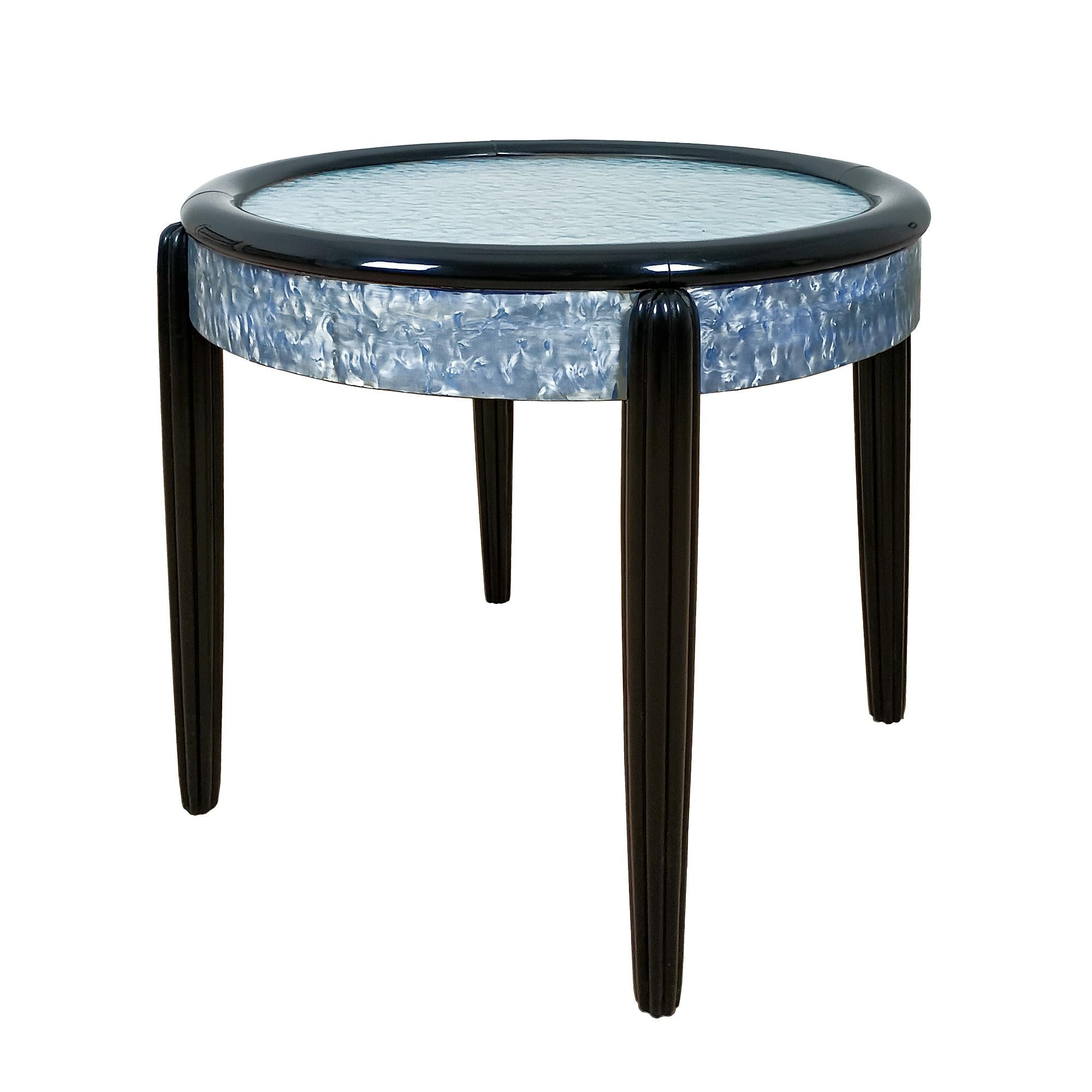 Side table with stained and varnished beech structure, surround and top upholstered in original blue celluloid (small losses).

France c. 1925.

 
