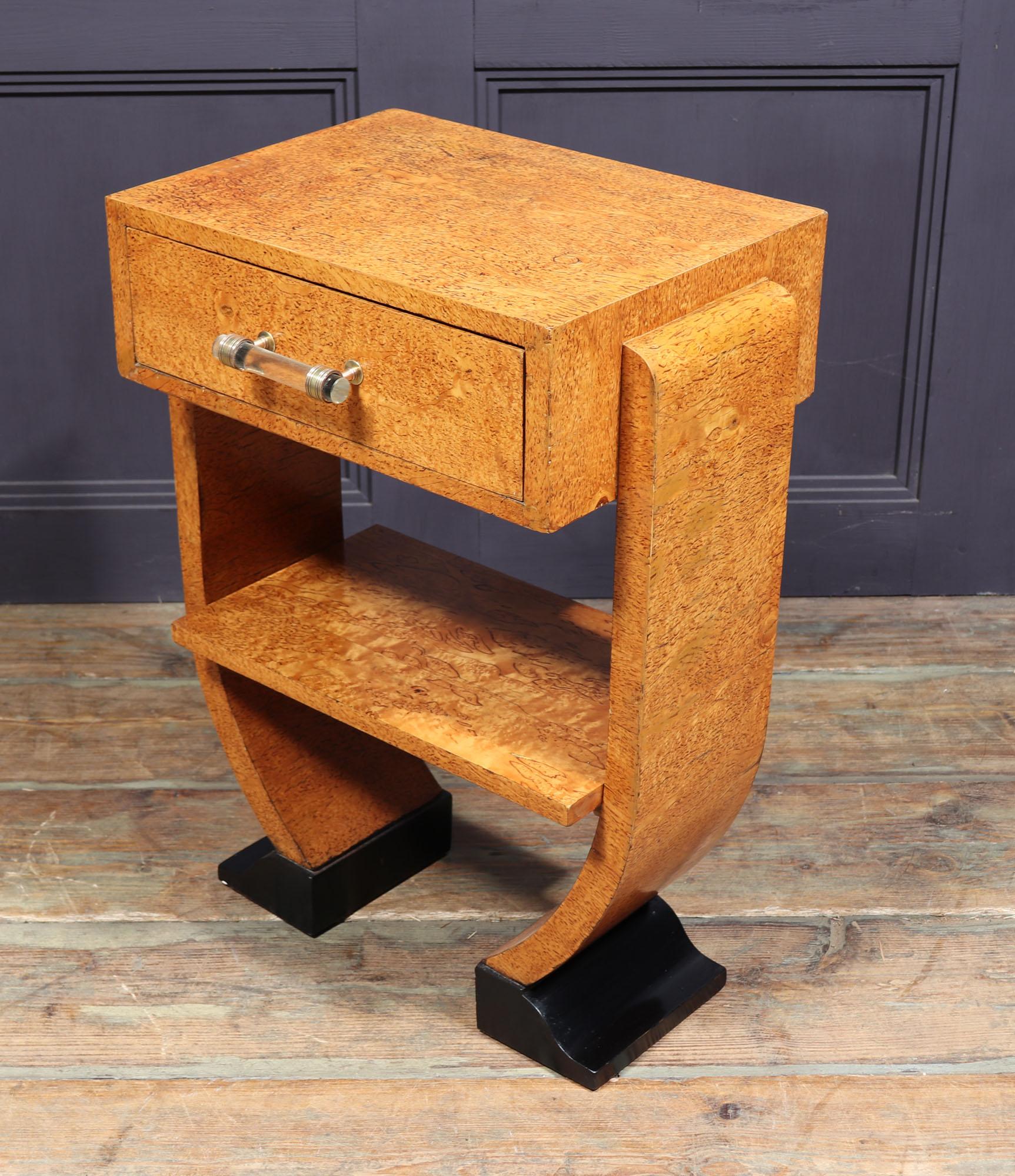 This original vintage art deco side table is a true find. Crafted from Karelian birch, it features exquisite geometric and symmetrical designs that are sure to be the envy of all. From its graceful shaped legs to its intricate glass handle, this