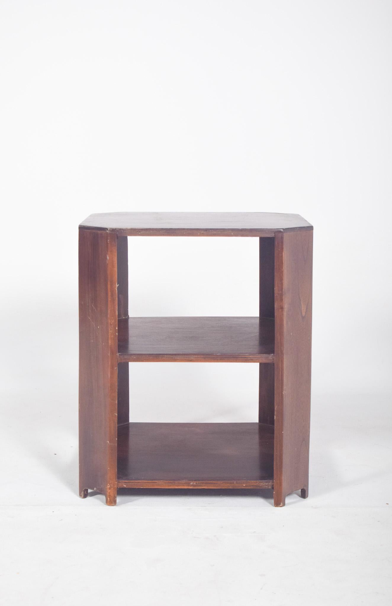 Deco coffee table in walnut. With three planes and a hexagonal structure with smoothly cut corners, a flat, smooth top with straight edges, a middle and bottom shelf with the same shape, aligned vertically and connected by straight, medium-thick