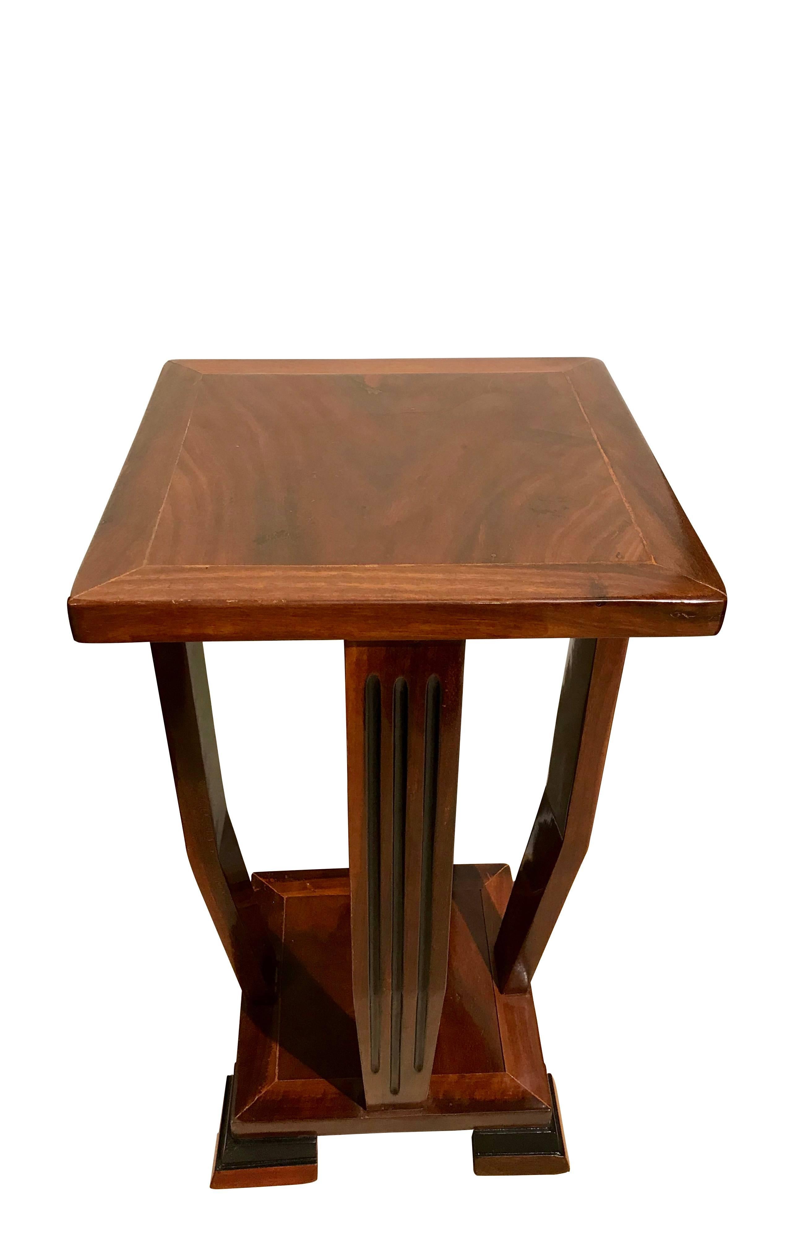 This very elegant Art Deco side-table is classic in its design and manufactured in very high quality. It has three blackened grooves in each of the four columns. The shellac hand-polish gives it a very precious high-gloss surface.