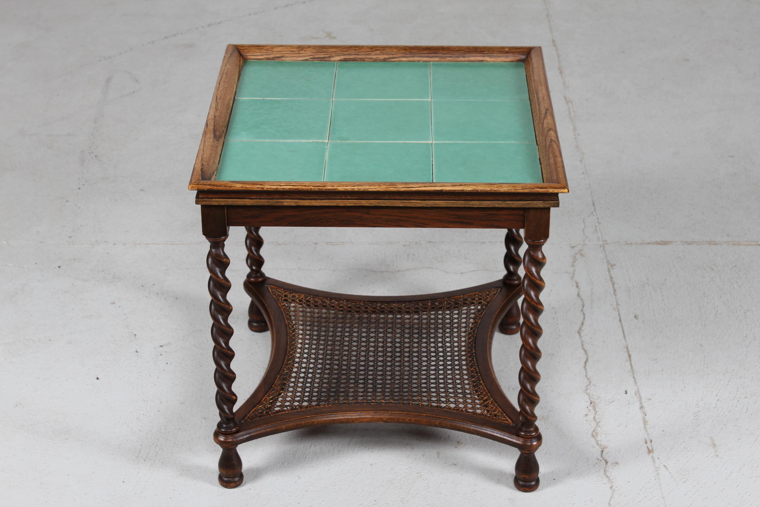 Danish Art Deco side table/ tile top table manufactured by Danish cabinetmaker in the 1930s-1940s.
The frame is made of dark stained wood with twisted turned legs.
Shelf of French cane and table top of jade green glazed tiles.

The table remains in