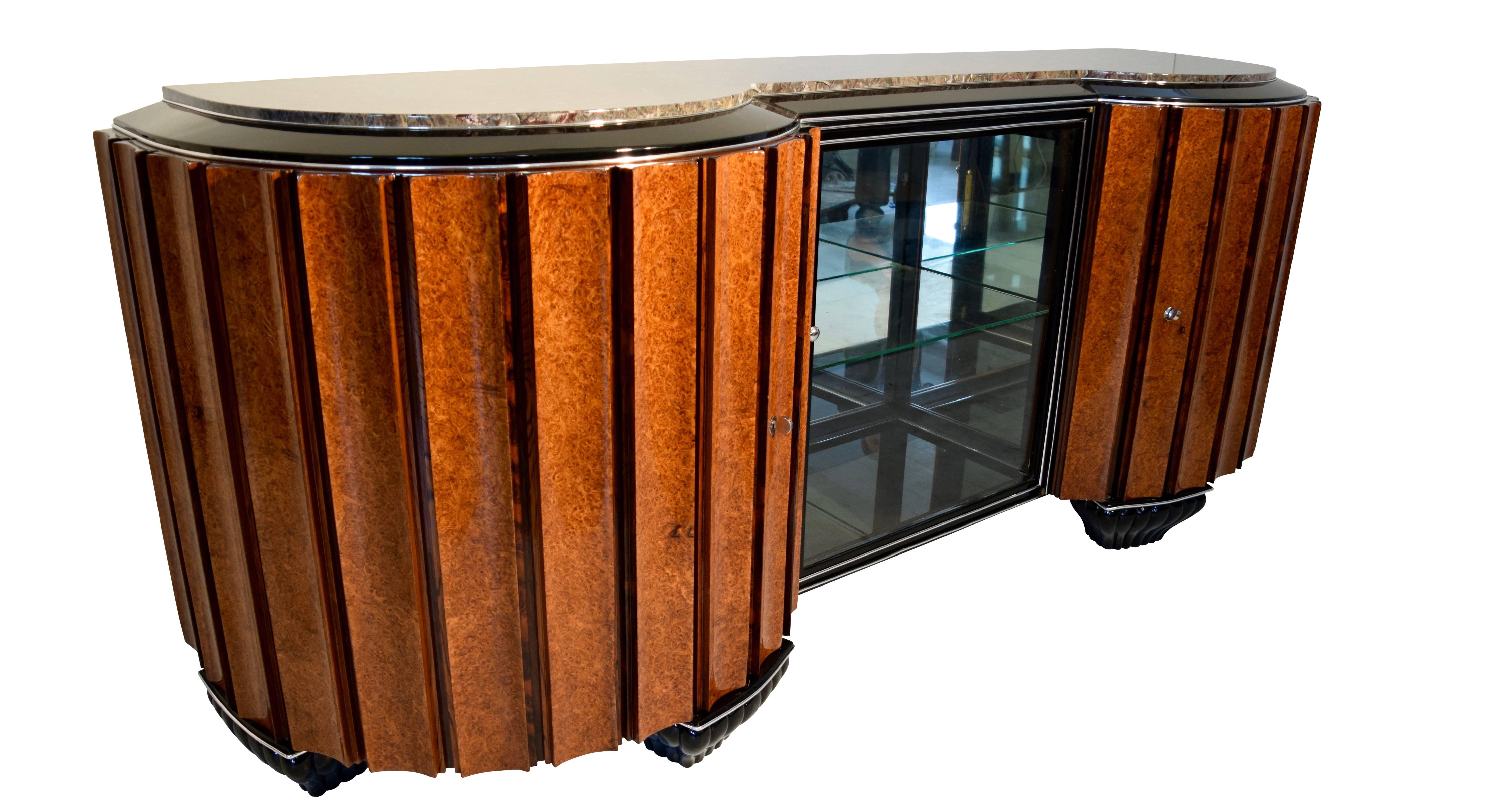 Stunning, large french Art Deco Sideboard or Buffet of excellent and heavy quality from Paris around 1925.
Amazing big concave fluted or cannelured doors, which can be folded out widely and are veneered in Amboyna burl wood as well as Rosewood