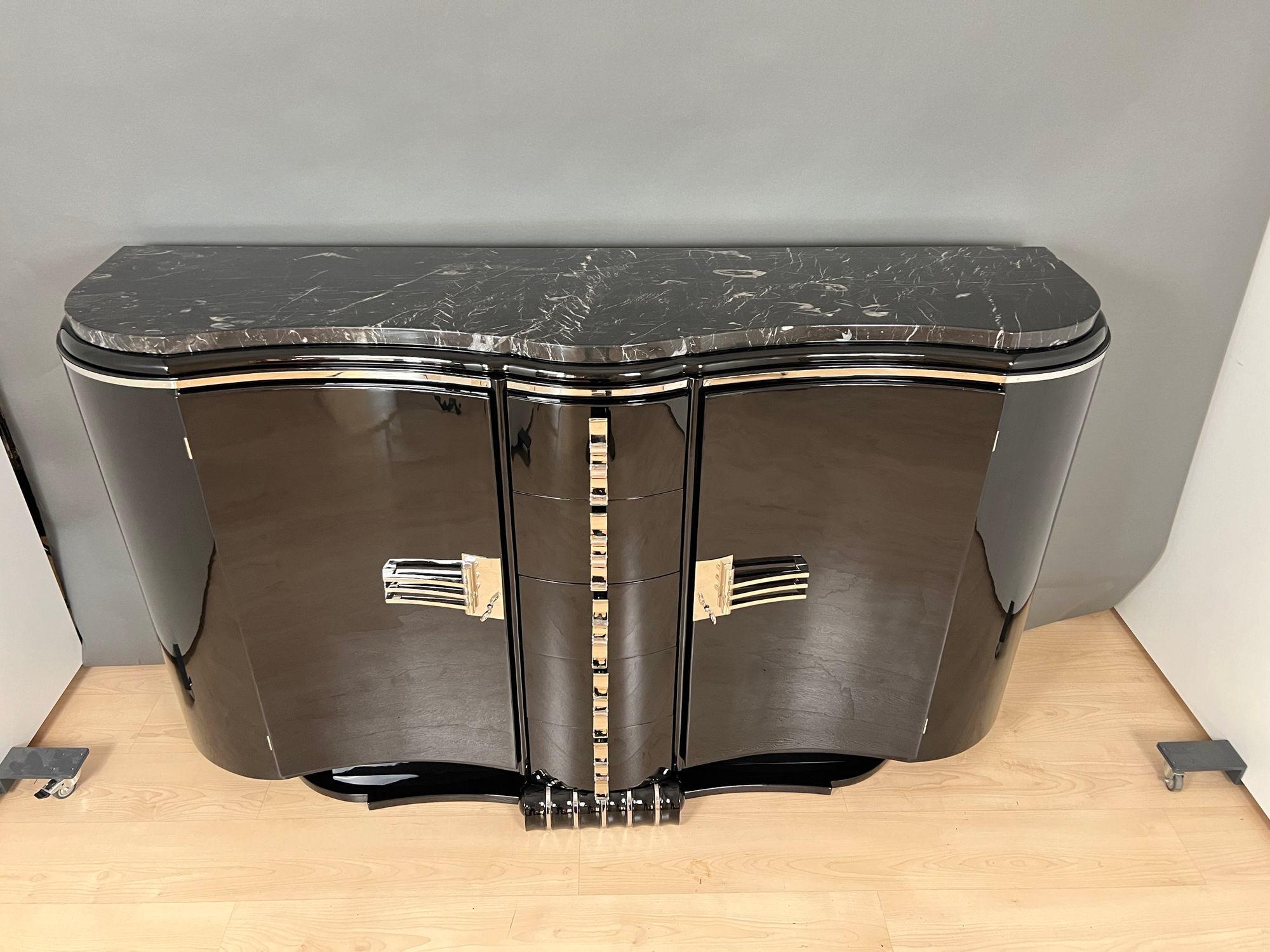 Large French Art Deco Sideboard or buffet from circa 1930. Fully restored, Black high gloss piano lacquer on wood. Elegantly curved art deco design. Top with original thick black marble top.
Original fittings, handles, hinges and locks. All metal