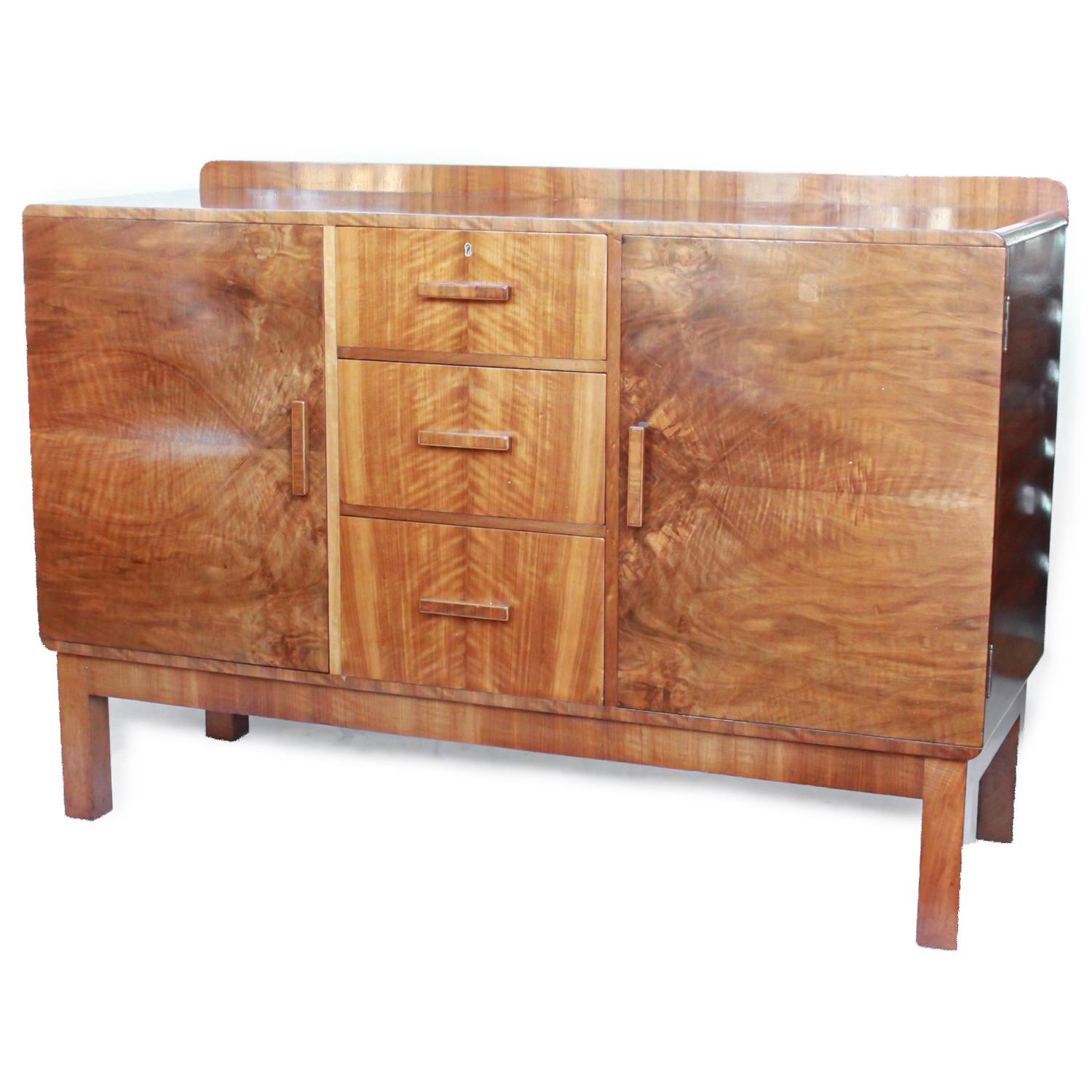 An Art Deco sideboard, with integral shelves and drawers. Original wooden handles. Burr and straight grain walnut veneer.

Dimensions: H 95cm, W 138cm, D 51.5cm 

Origin: English

Date: circa 1930

Item No: 2410191.