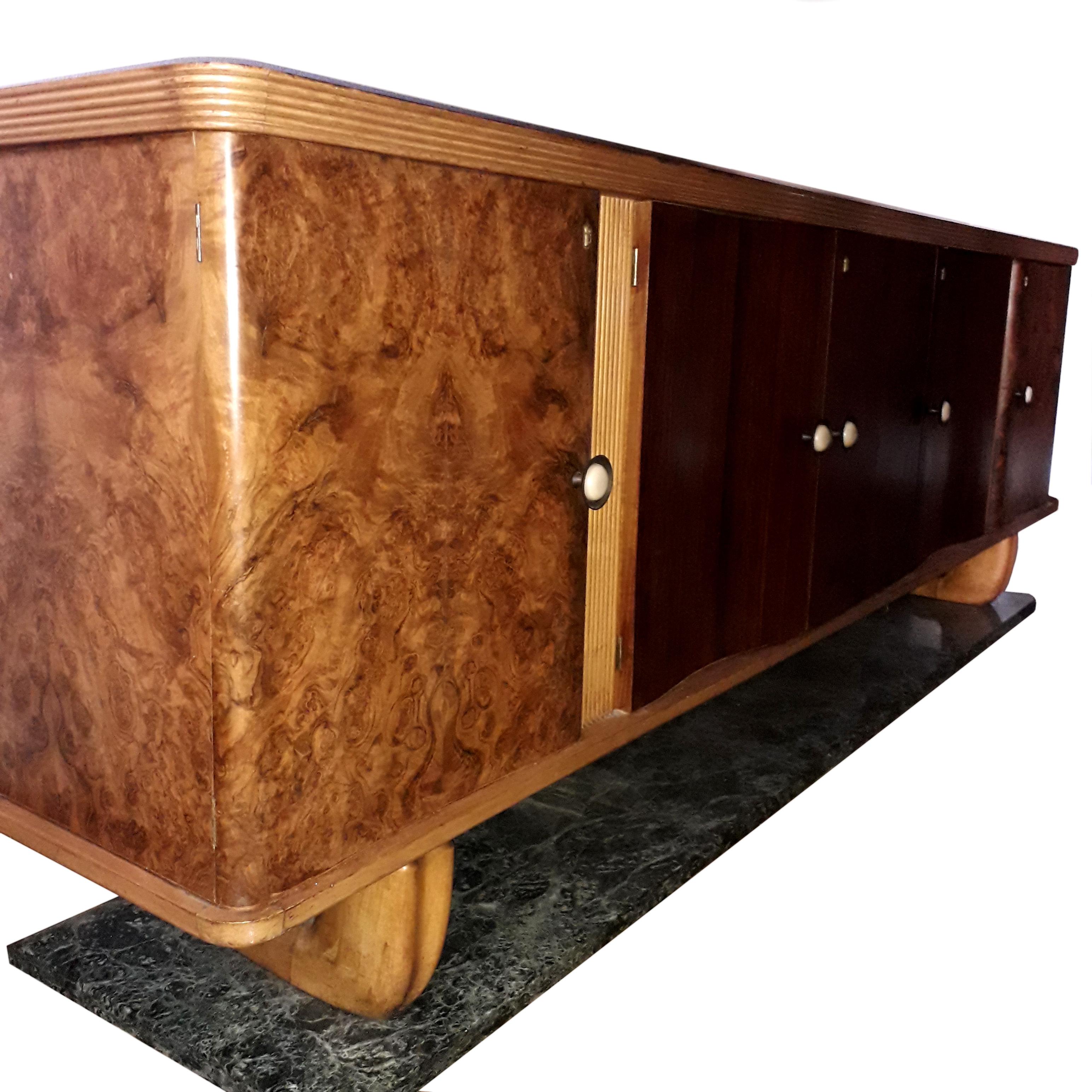 Art Deco sideboard designed by Vittorio Dassi, Milan.

The body with the curved facade, opens with five doors in rosewood veneer and burr walnut, discovering a maple sycamore interior. Connected by two feet in massive sycamore, the whole rests on