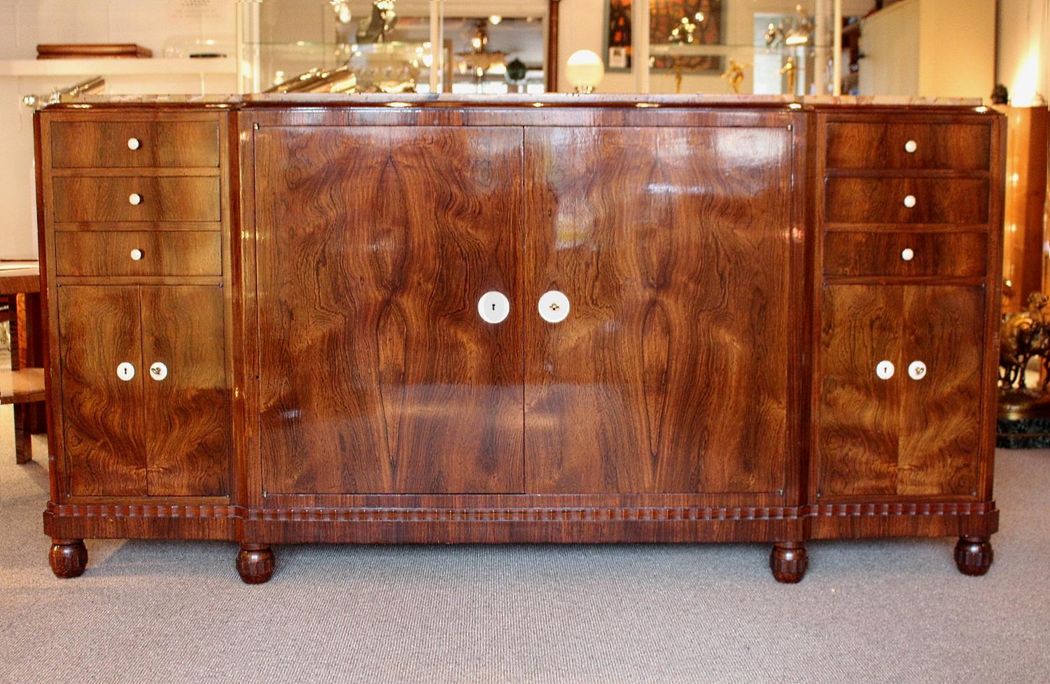 An Art Deco sideboard designed and executed by J&M Leleu, Paris (Jules and Marcel Leleu atelier).

Art Deco Complete, Alastair Duncan p.420

Palisander wood with ivorine handles and detail with marble top. Set over shaped bun feet. Central