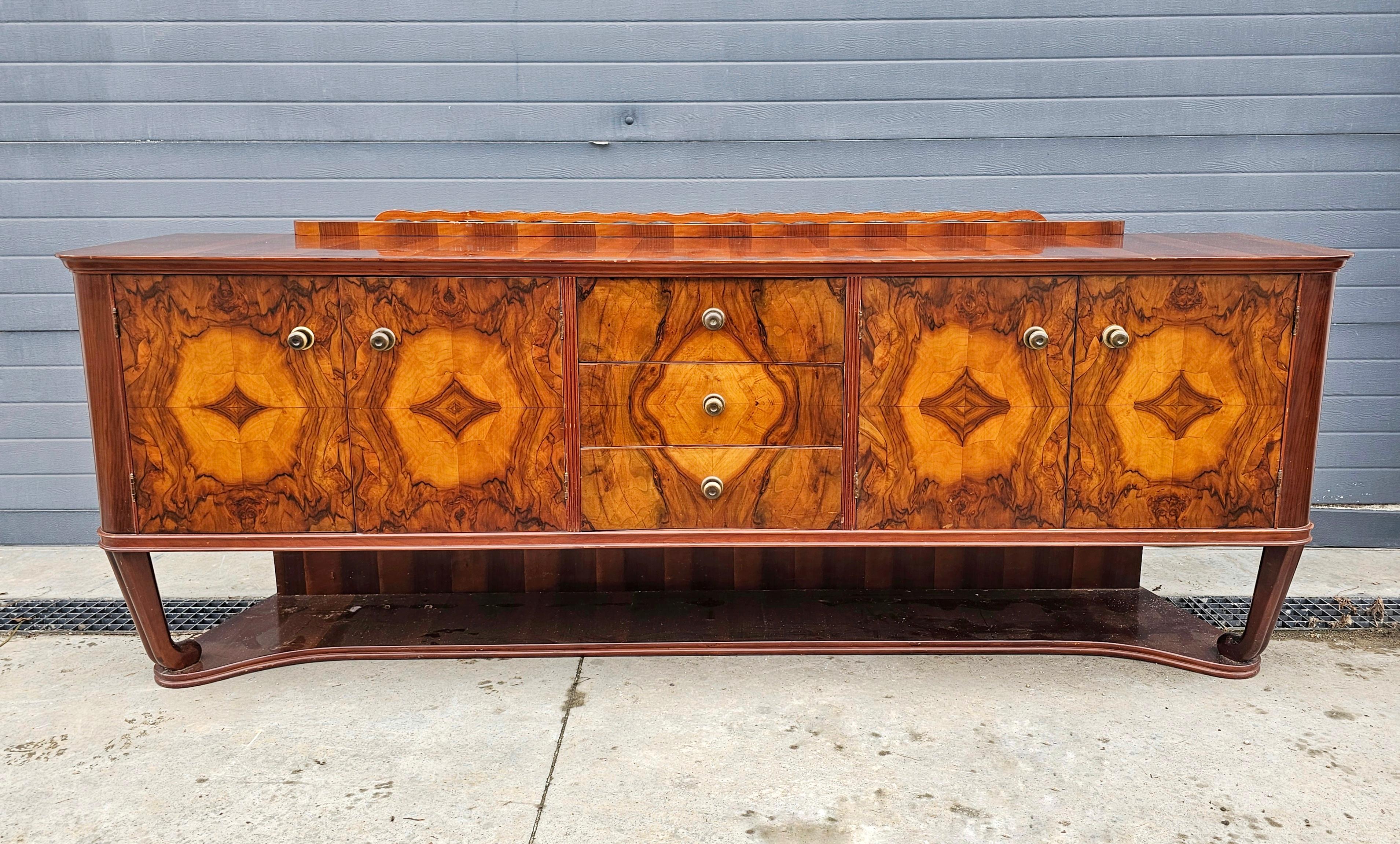 In this listing you will find a gorgeous XXL Art Deco sideboard done in walnut, with stunning walnut burl veneer. It features 4 doors behind which you can find 2 large compartments. In addition to that, there are 3 drawers in the middle. Original