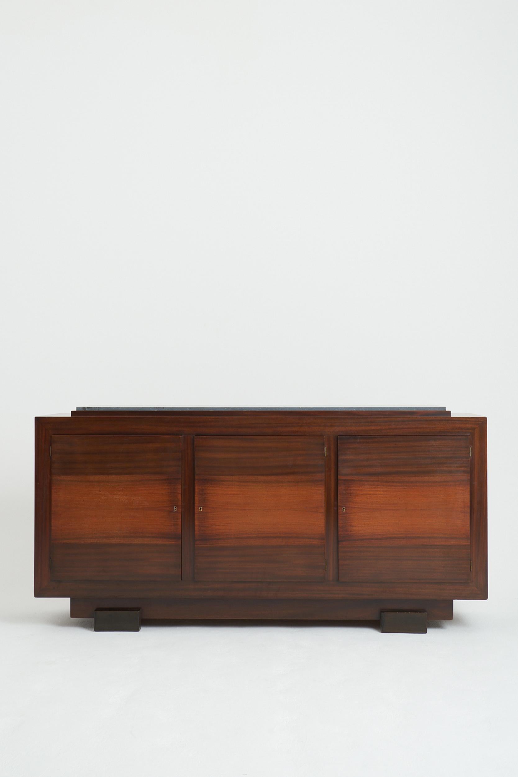 An Art Deco mahogany and black stone top three-door sideboard.
France, Circa 1930
99 cm high by 200 cm wide by 50 cm depth
