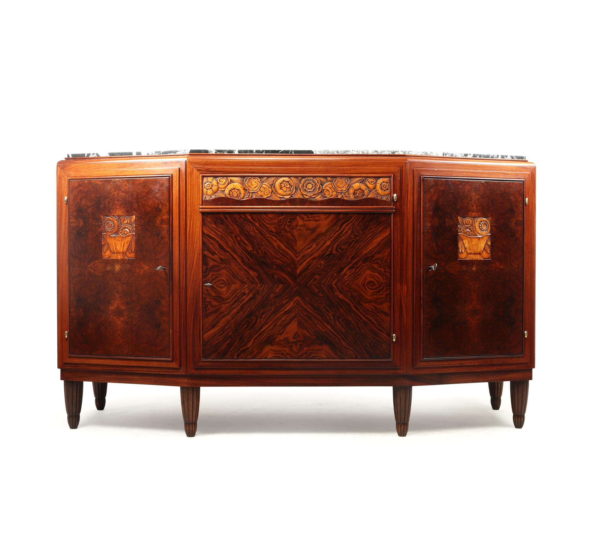 A French Art Deco sideboard produced in Paris in the 1920’s black and white marble top on a solid oak framed cabinet with amboyna and rosewood with carved motifs of flowers and fruits, lined in light blonde sycamore with excellent quality locks.