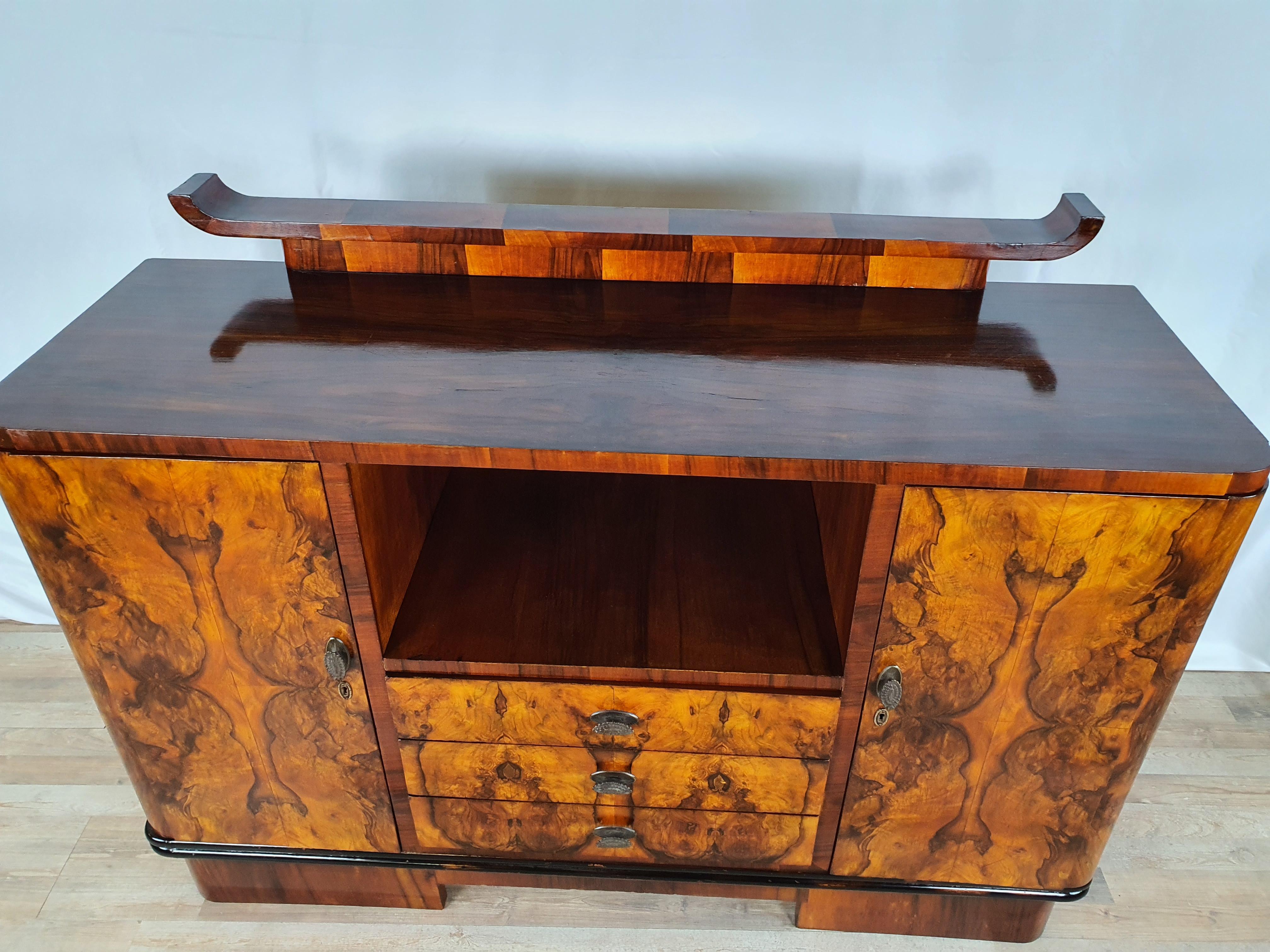Fine and elegant sideboard from the Decò era, oil polished and shellac, ready to be placed in a living room, dining room or even as an entrance furniture thanks to the two doors and three central drawers.

Note the contrast of the briar, it is a