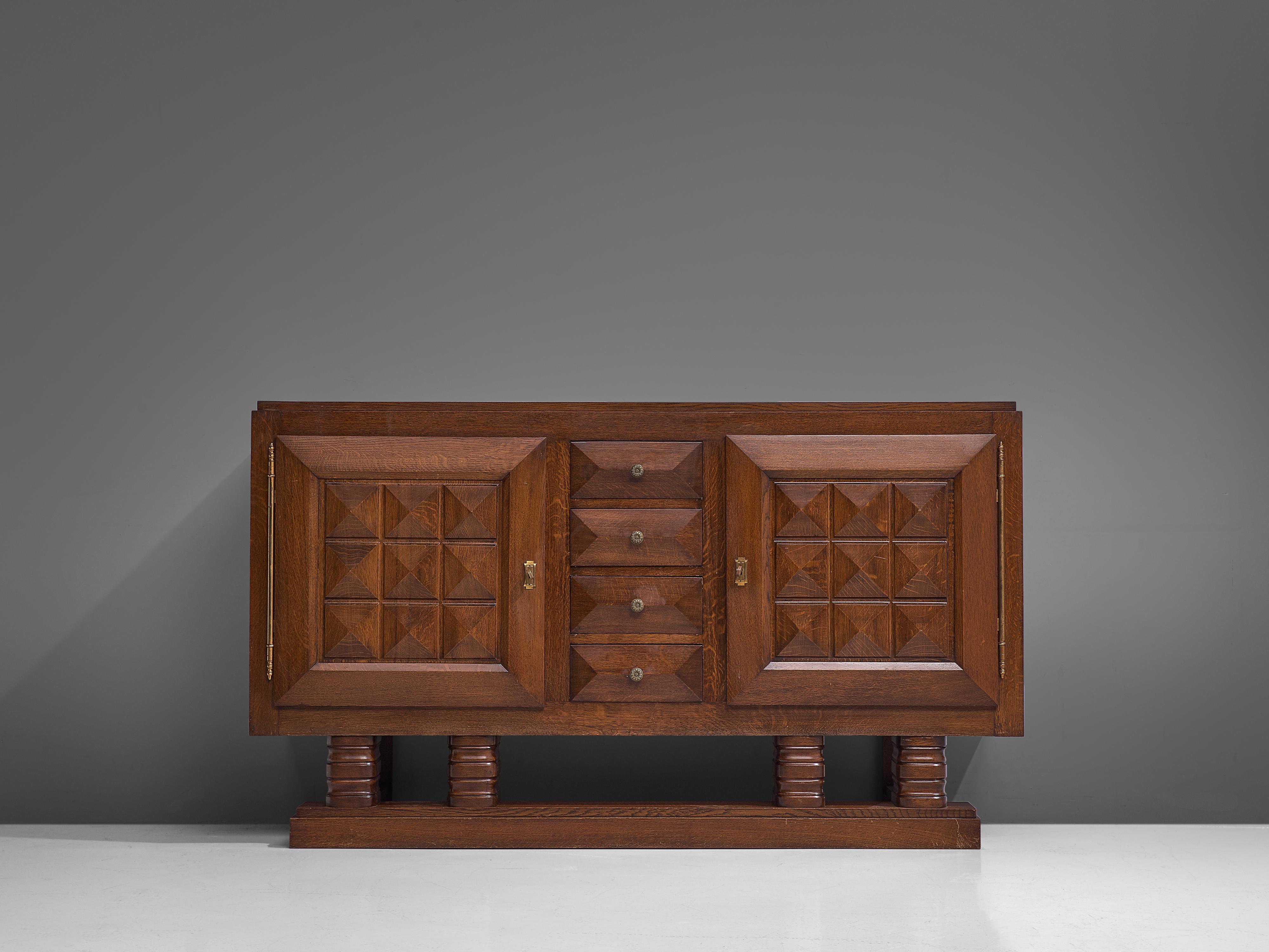 Gaston Poisson, sideboard, stained oak, brass, France, 1930s

Elegant and strong sideboard in stained oak with graphical door panels and drawers. The sideboard is equipped with drawers flanked by two doors. The door panels and base show the great