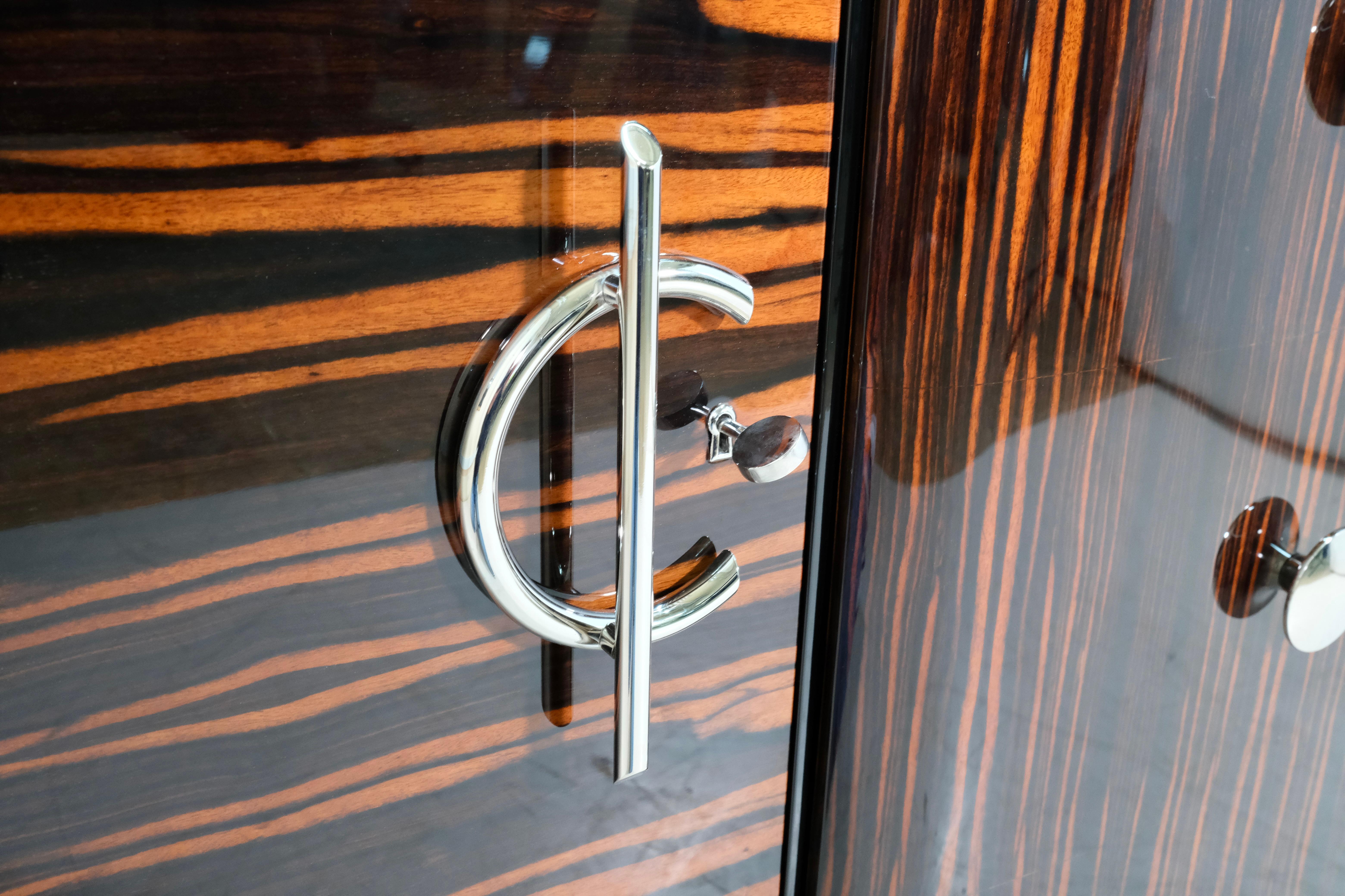 Questa straordinaria credenza francese Art Déco degli anni '30 mette in mostra la sofisticata materialità e la raffinata geometria che definivano i mobili più esclusivi dell'epoca. Il corpo è rivestito in Macassar riccamente lavorato, le cui