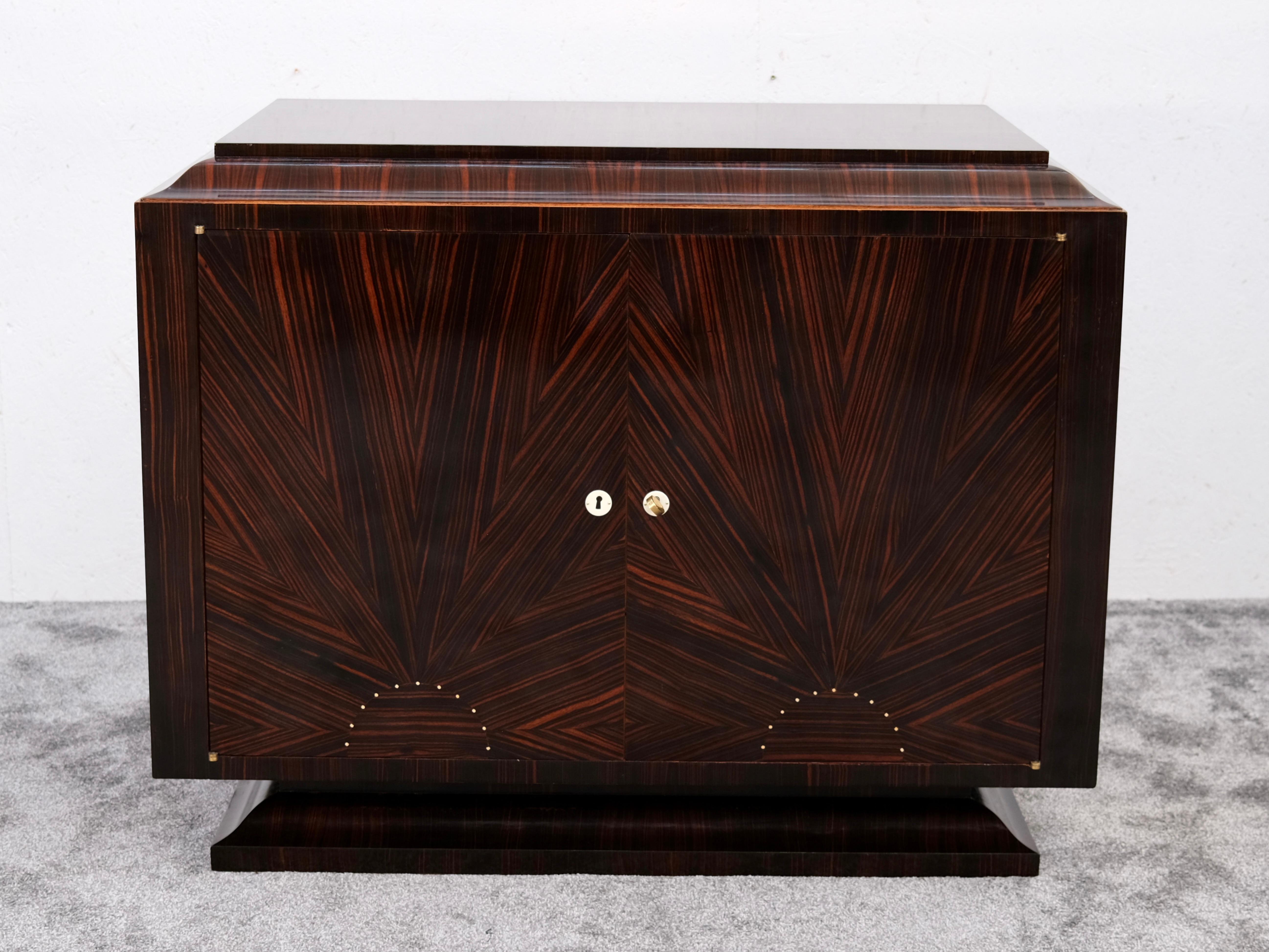 An exceptional piece of French Art Deco craftsmanship: At first glance, this elegant cabinet presents itself as a classic sideboard. But once the two doors swing open, it reveals its true identity – a beautifully designed chest of drawers with three