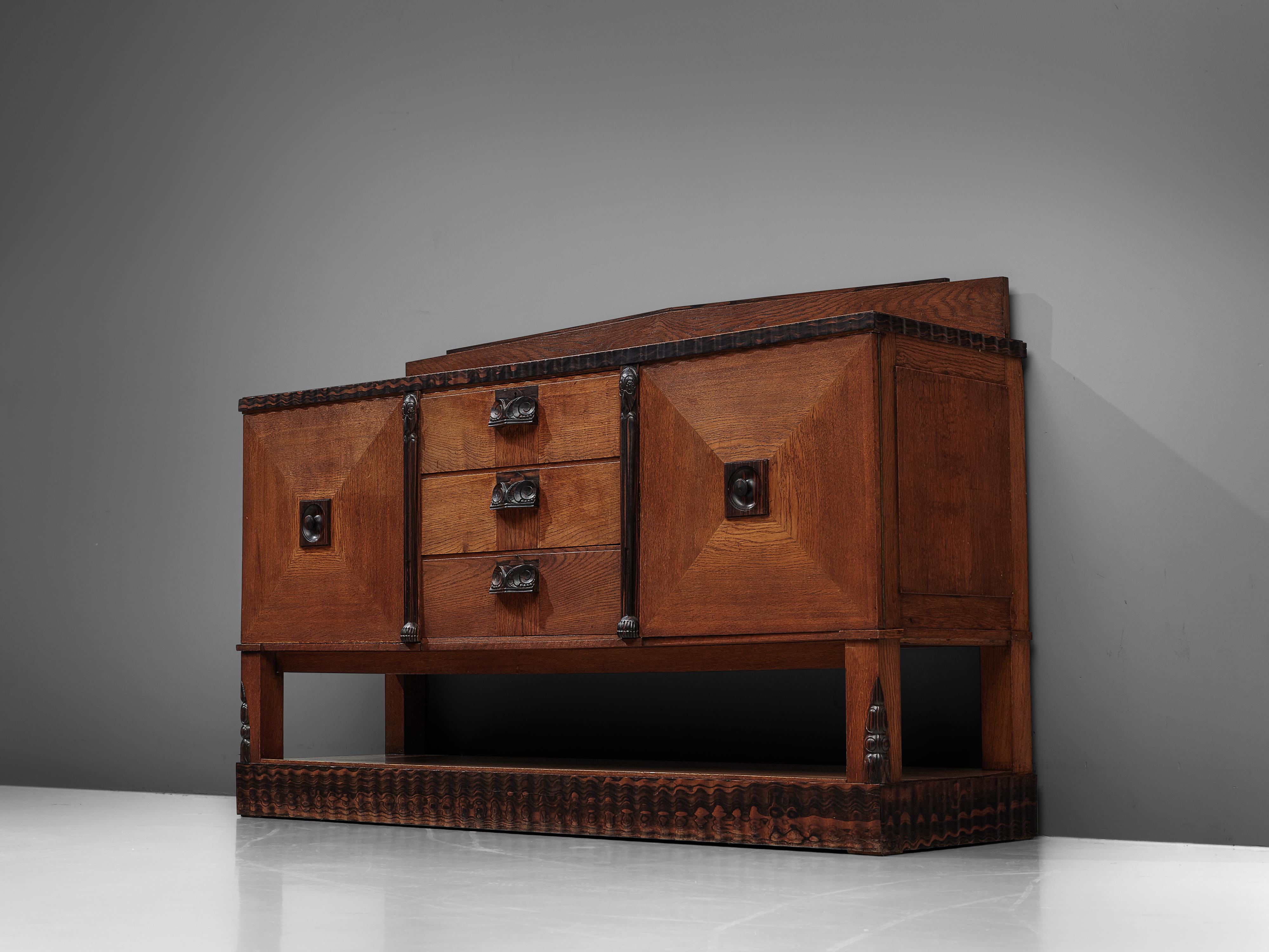 Sideboard, darkened oak, striped ebony, the Netherlands, 1930s

Dutch Art Deco sideboard with carved details in striped ebony. Truly striking about this sideboard is the woodwork in oak and striped ebony. The sideboard is made of oak, with oak