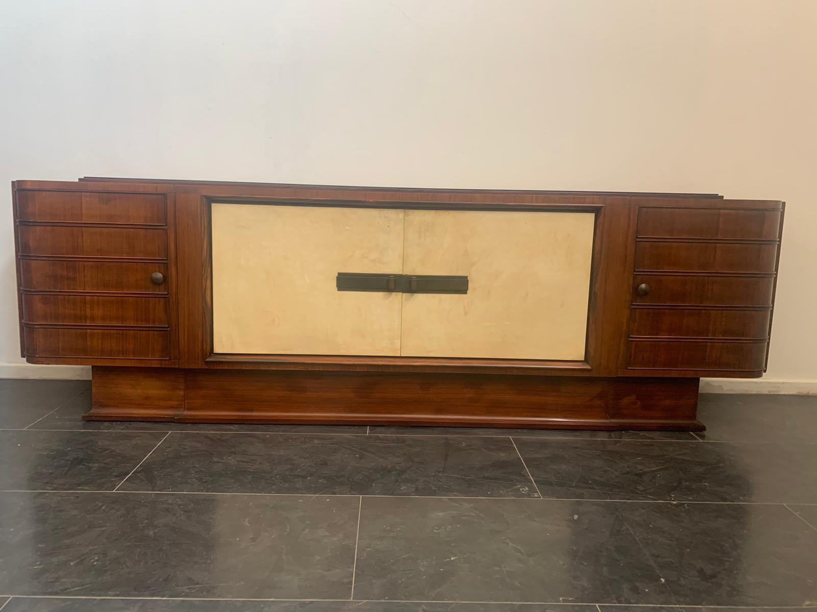 Aparador Art Decó de palisandro y pergamino con tapa de cristal negro.
En el estilo de Osvaldo Borsani (tengo pruebas oficiales de autenticidad, como catálogos de época, documentos de diseño u otras fuentes literarias).
Se incluye el embalaje con