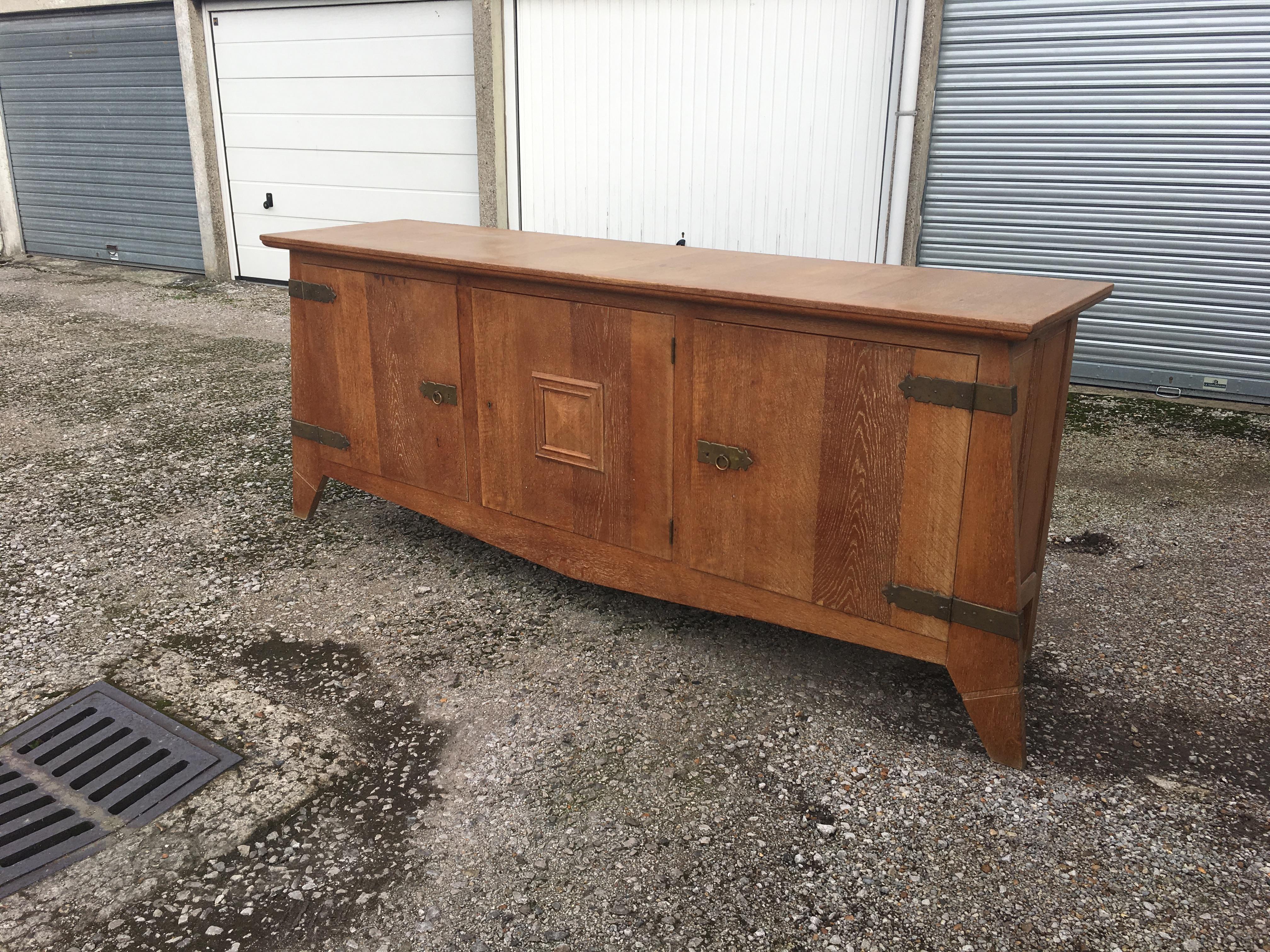 Art Deco sideboard in solid oak and oak veneer, and brass, circa 1940.
Small gaps in veneer on the back of the board.
the patina is a little dirty and needs to be redone