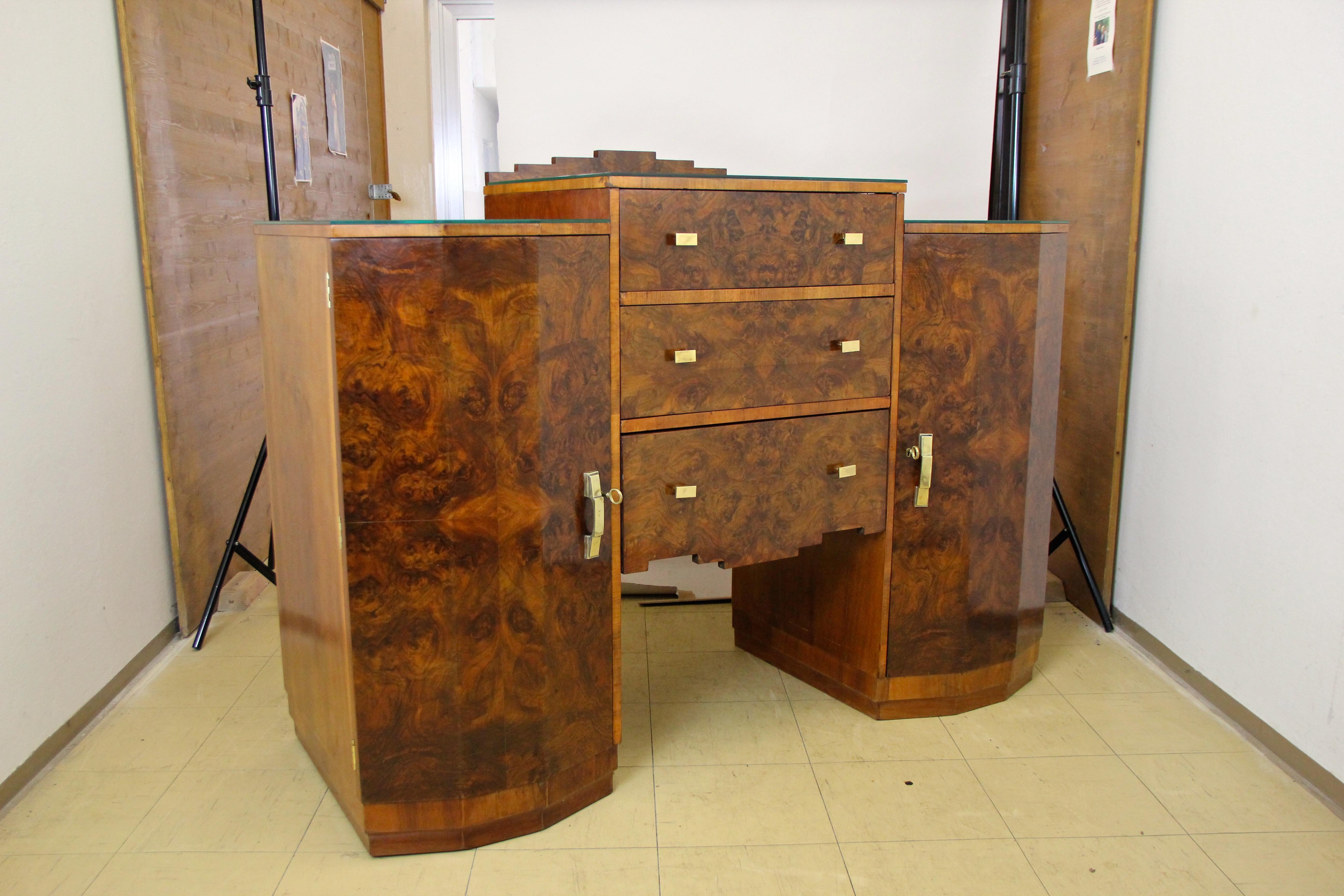 Unique designed Art Deco sideboard or buffet out of Austria from the period circa 1925. This unusual shaped side board impresses with an absolute great book matched burr walnut veneer, giving it a real mesmerizing grain. The exceptional design with