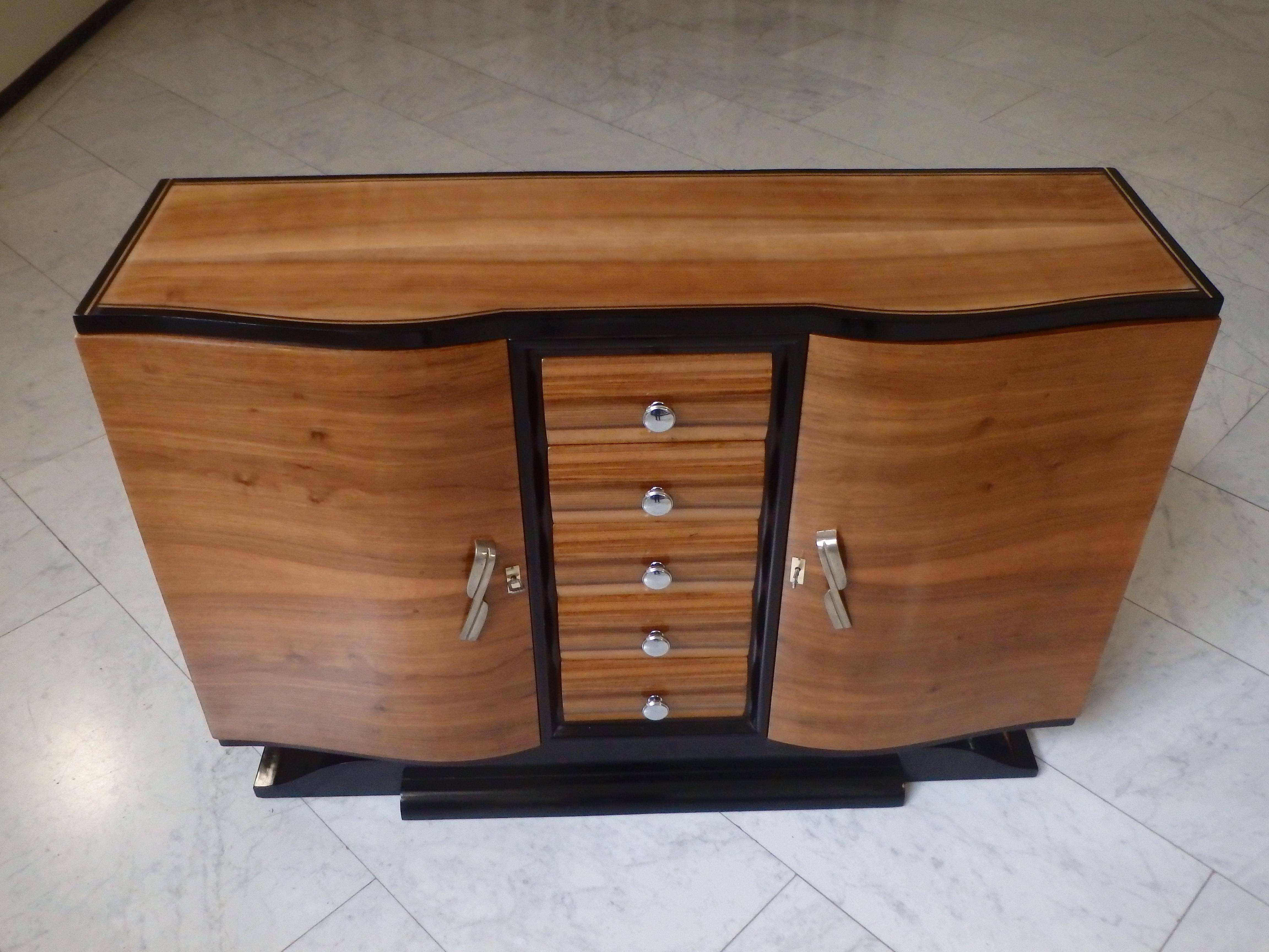 Art Deco sideboard with 5 drawers rounded doors chrome handles mustache foot
has one shelf on each side . Elegant and sophisticated with black highlights