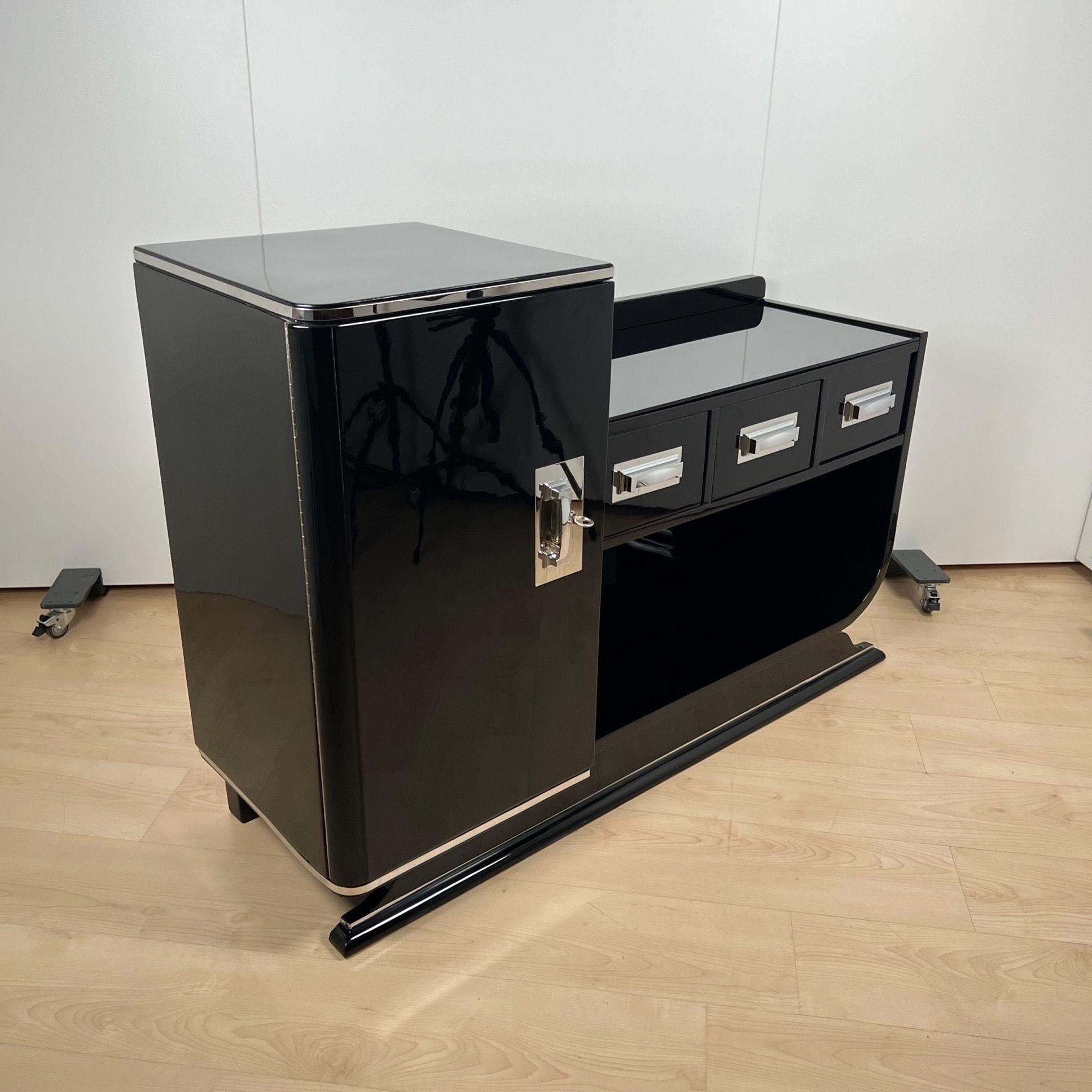 Credenza o credenza Art Déco con vano bar in legno laccato nero, proveniente dalla Francia intorno al 1930.
Design a gradini, lato sinistro alto con vano bar con serratura, lato destro con cassetti e vano aperto sottostante.
Bar sinistro all'interno