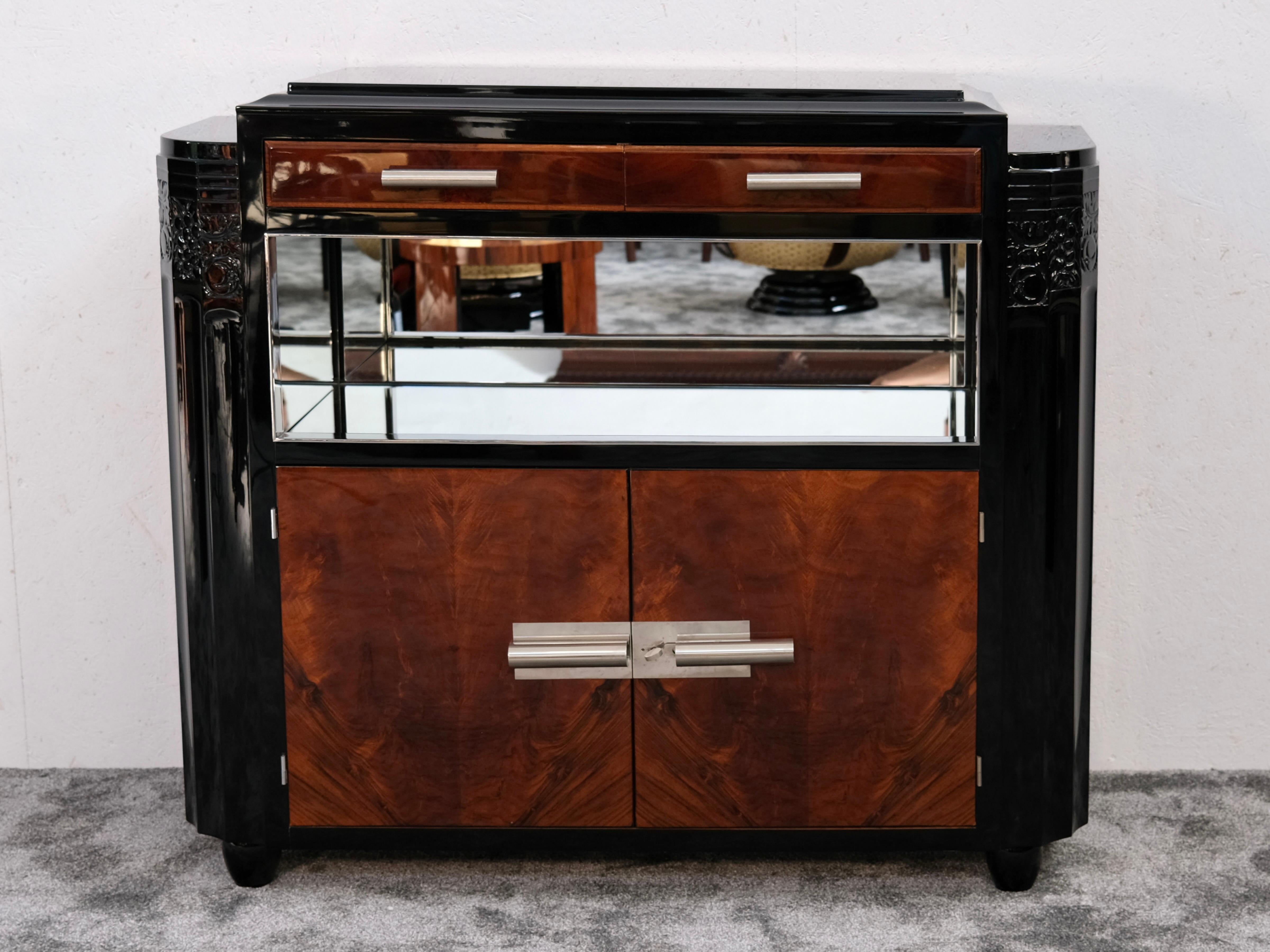 A striking example of French Art Deco design from the 1930s – this restored sideboard blends clean geometry with decorative flair, noble materials with functional sophistication.

Its black high-gloss lacquered body is beautifully contrasted by the