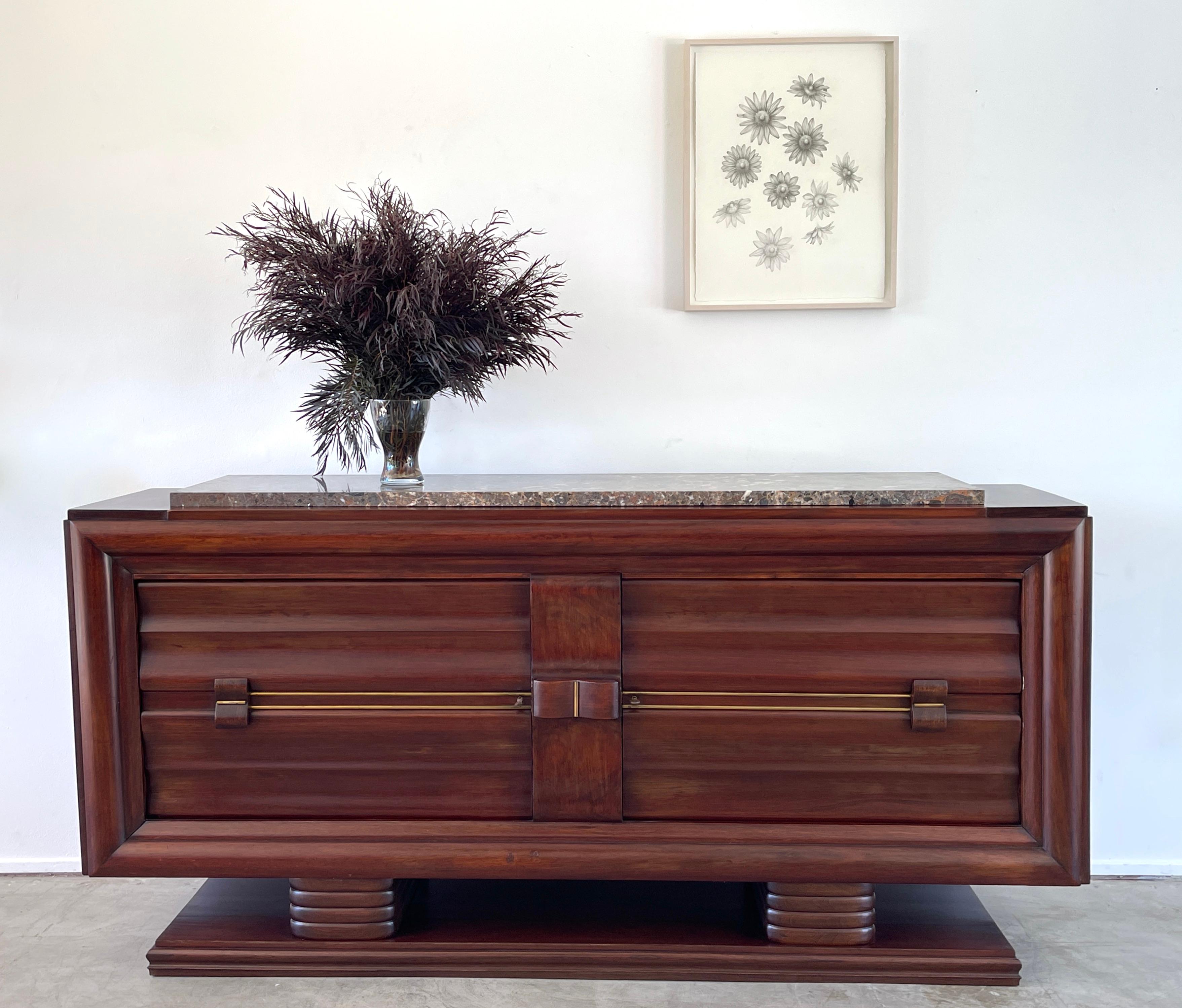 Incredible Art Deco Italian sideboard with marble top and simple clean lines

Brass inlaid and hardware / original dark wood stain 

2 Door cabinet opens to reveal hidden drawer with inlaid detail 

Undulating wood legs on plinth 

Incredible